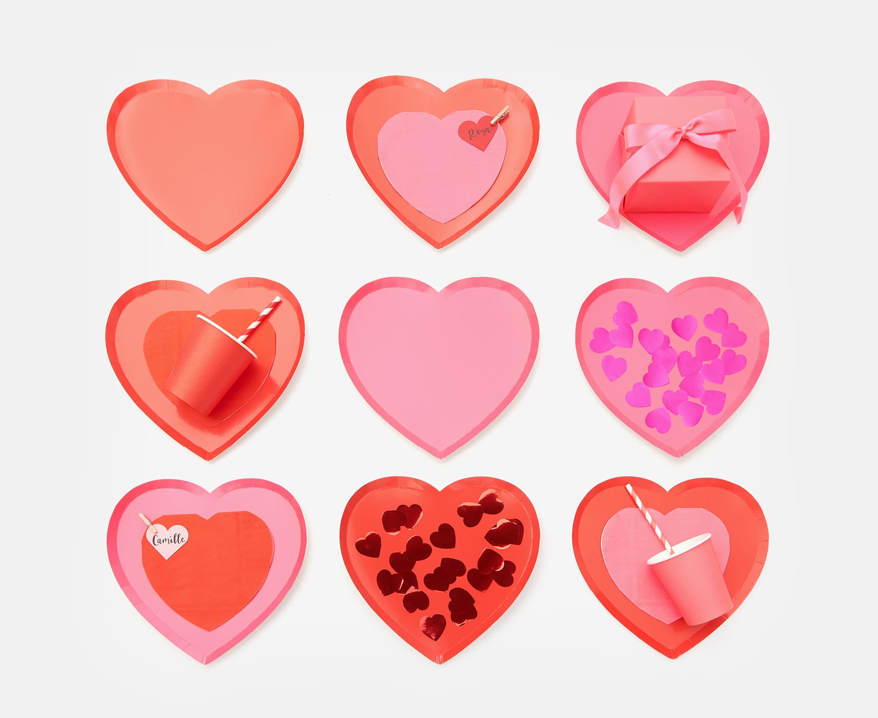 Pappteller in Herzform sind mit Pappbechern, Servietten und Herz-Konfetti dekoriert.