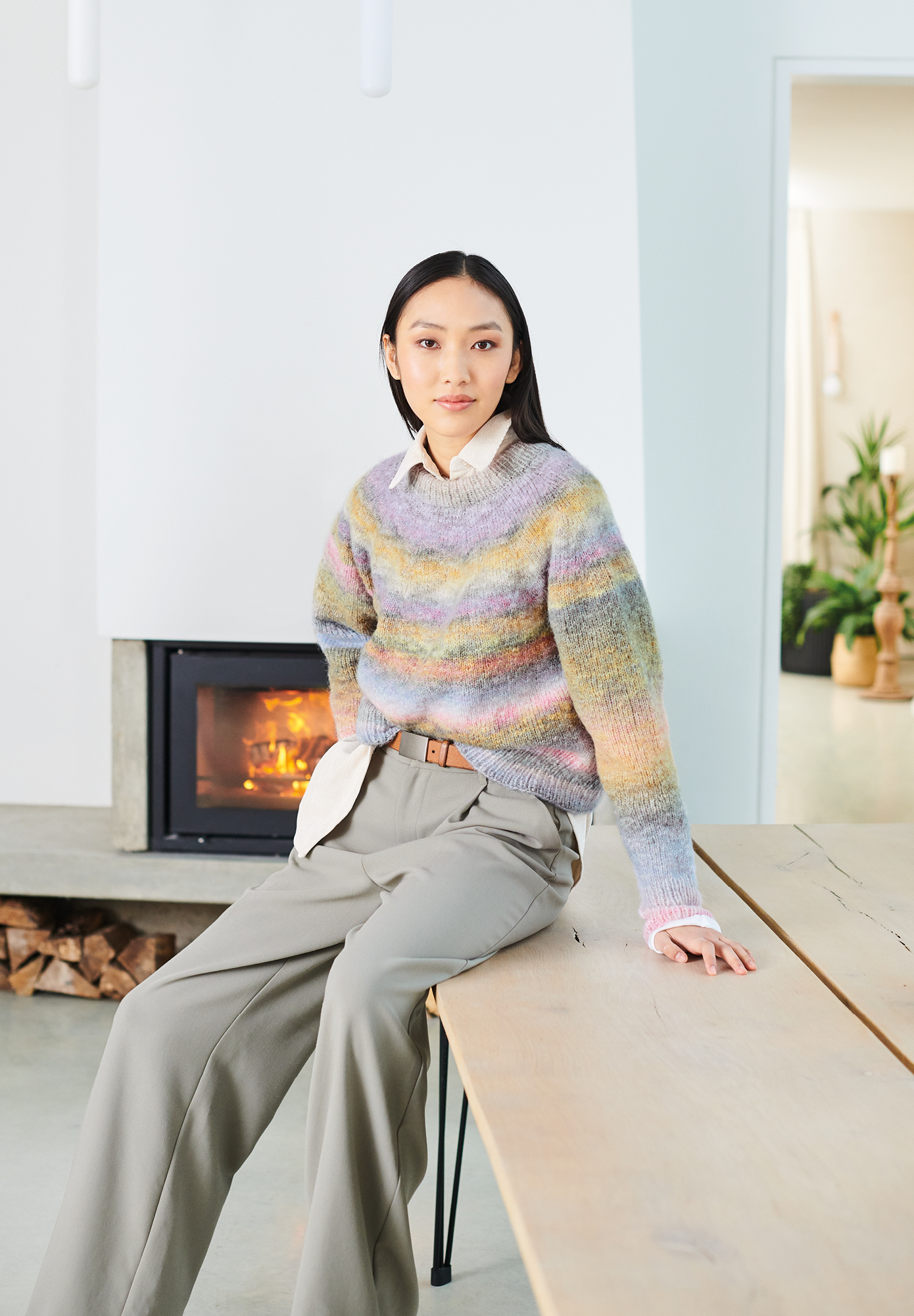 Frau trägt gestrickten Pullover mit buntem Farbverlauf: Modell 20 aus Lovewool No. 19