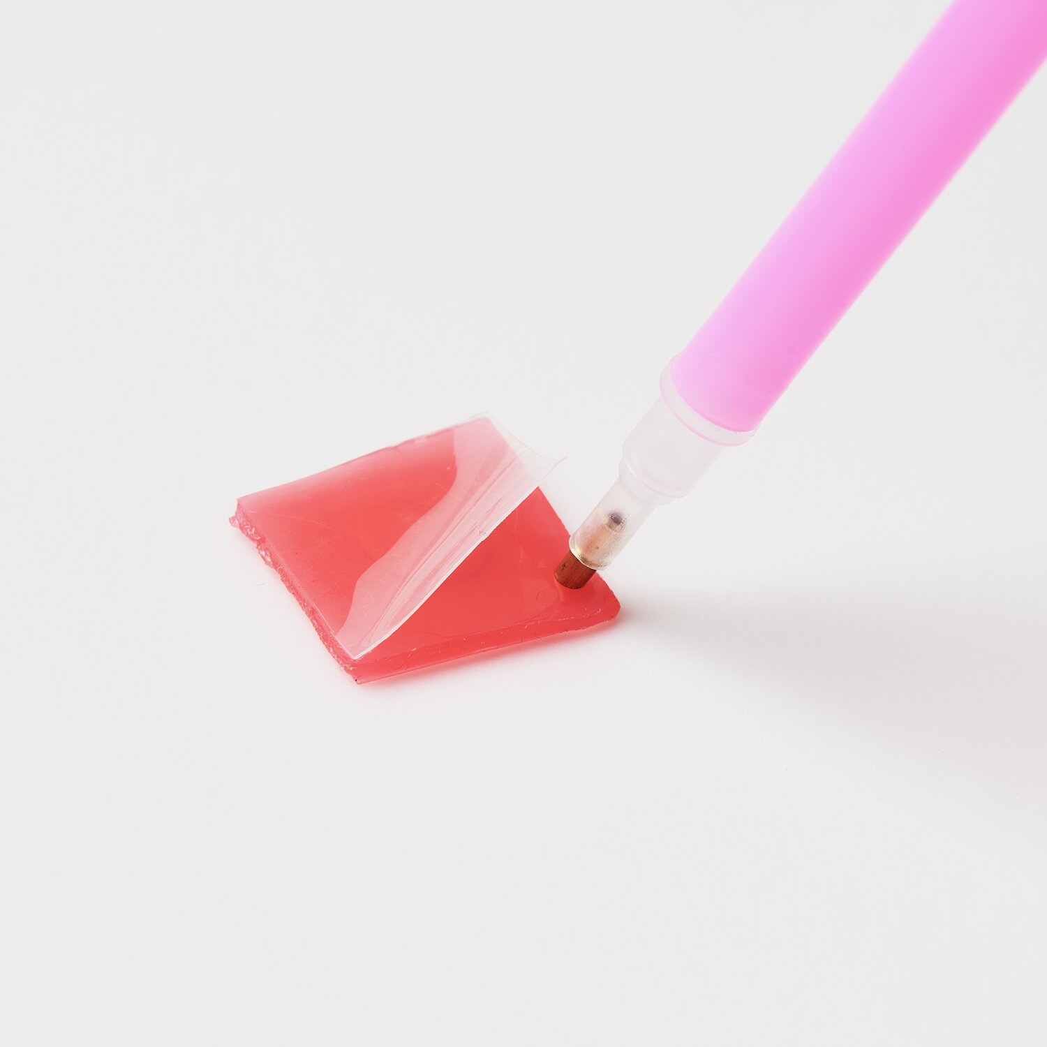 Diamond Painting DIY-Set Frühlingswiese 31x18,5cm: Ein pinker Stift nimmt roten Kleber auf.