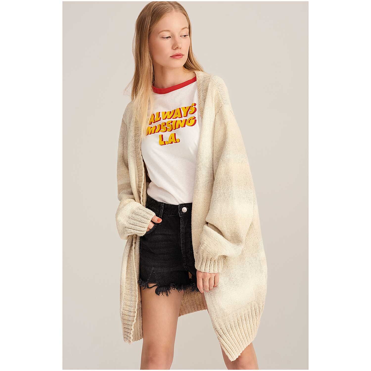 Fashion Cotton Light & Long dk: Frau trägt langen, beigen Cardigan von Rico Design über T-Shirt und Shorts.