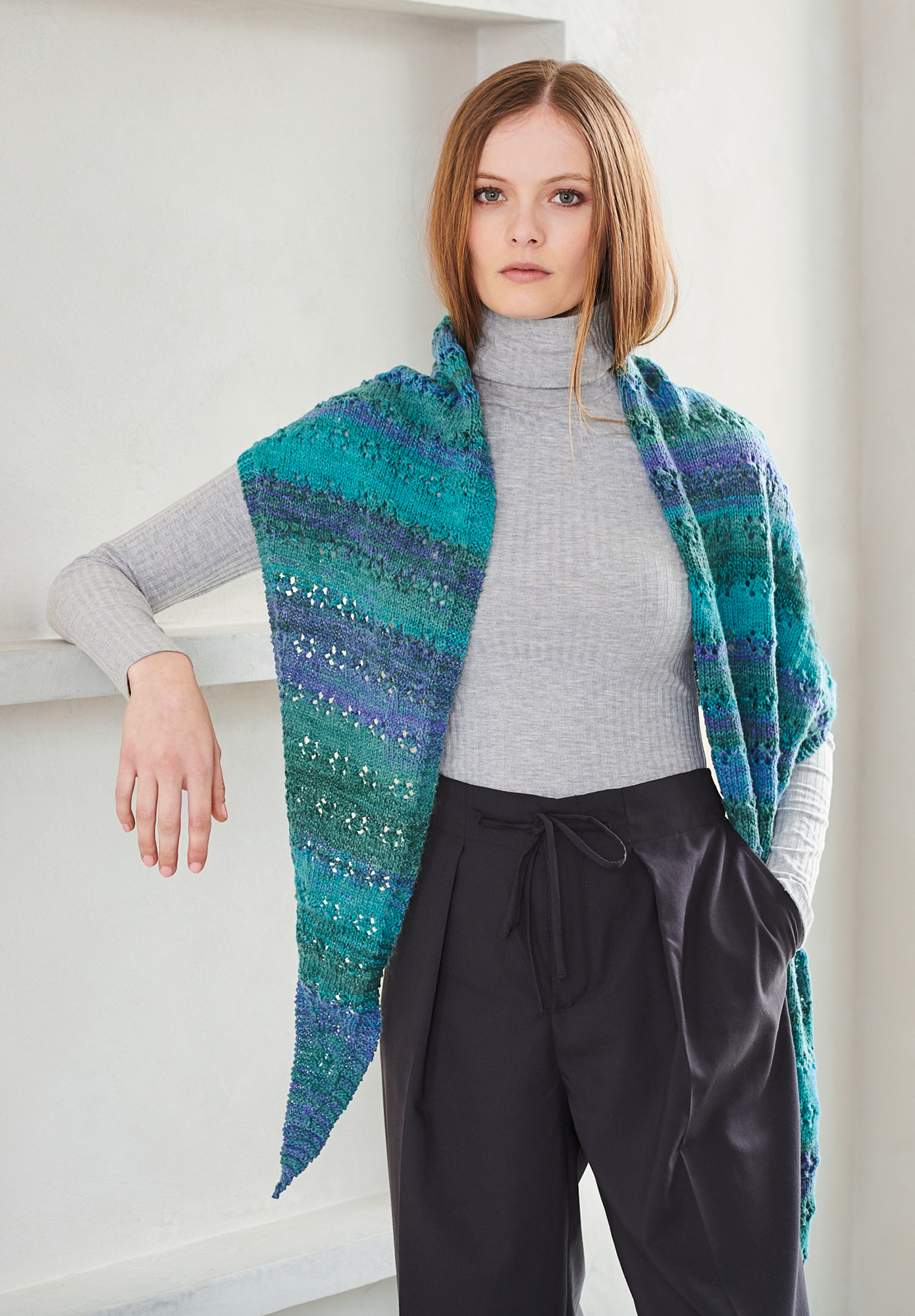 Frau trägt gestricktes Dreieckstuch in Blau-Grün Tönen: Modell 04 aus Lovewool No. 19