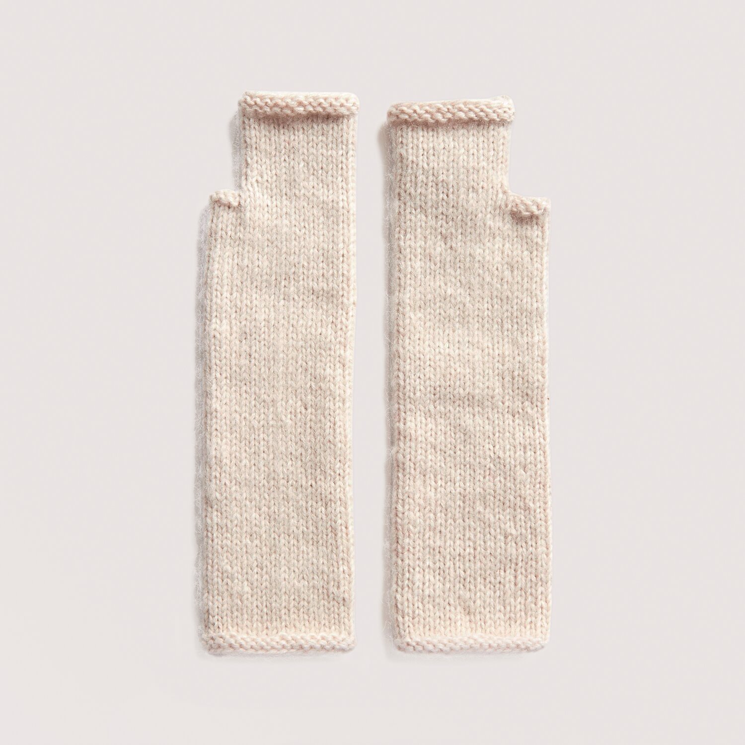Luxury Knits - Premium Natural Fibres Sprachauswahl deutsch von Rico Design Strickset Stulpen Modell 02 aus Luxury Knits: Cremefarbene, handgestrickte Stulpen aus natürlichen Fasern auf hellem Hintergrund.