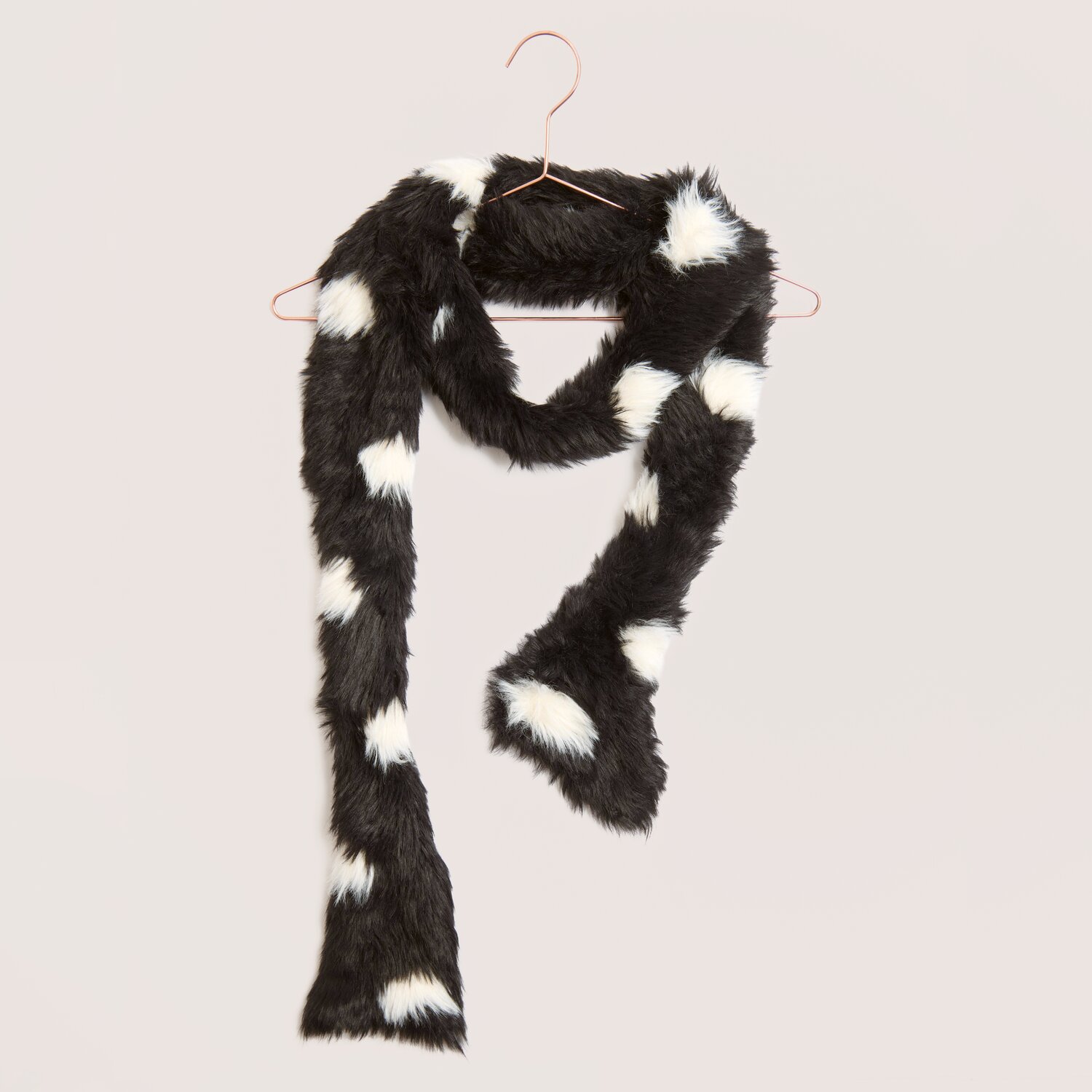 Creative Fur, kuscheliger Kunstfell-Schal mit länglicher Form, schwarz mit weißen Flecken, Rico Design, Subtitel 100g 130m, dekorativ auf Bügel drapiert