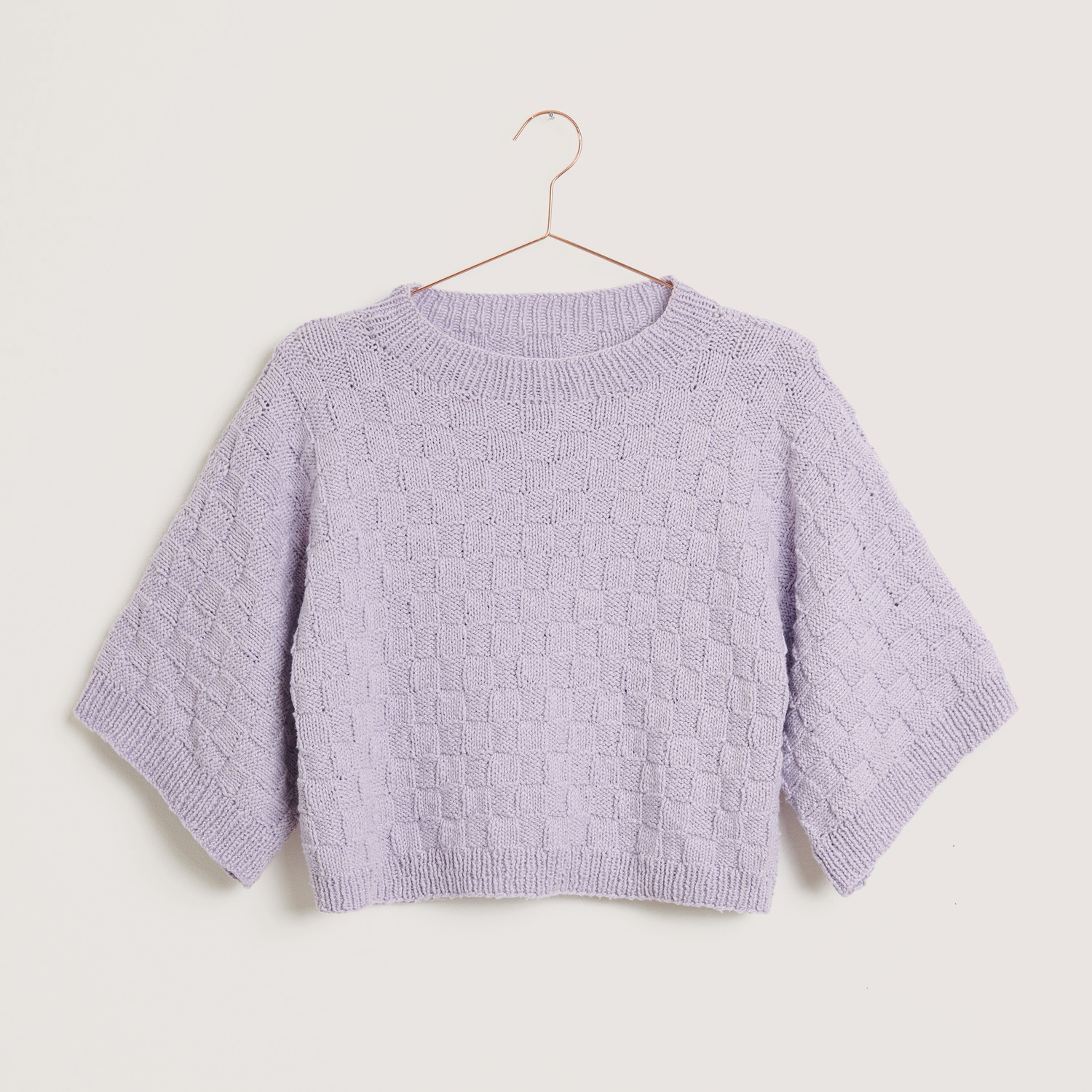 Essentials Super Cotton dk: Fliederfarbener Strickpullover mit kurzem Schnitt und 3/4-Ärmeln, präsentiert auf einem Kleiderbügel.