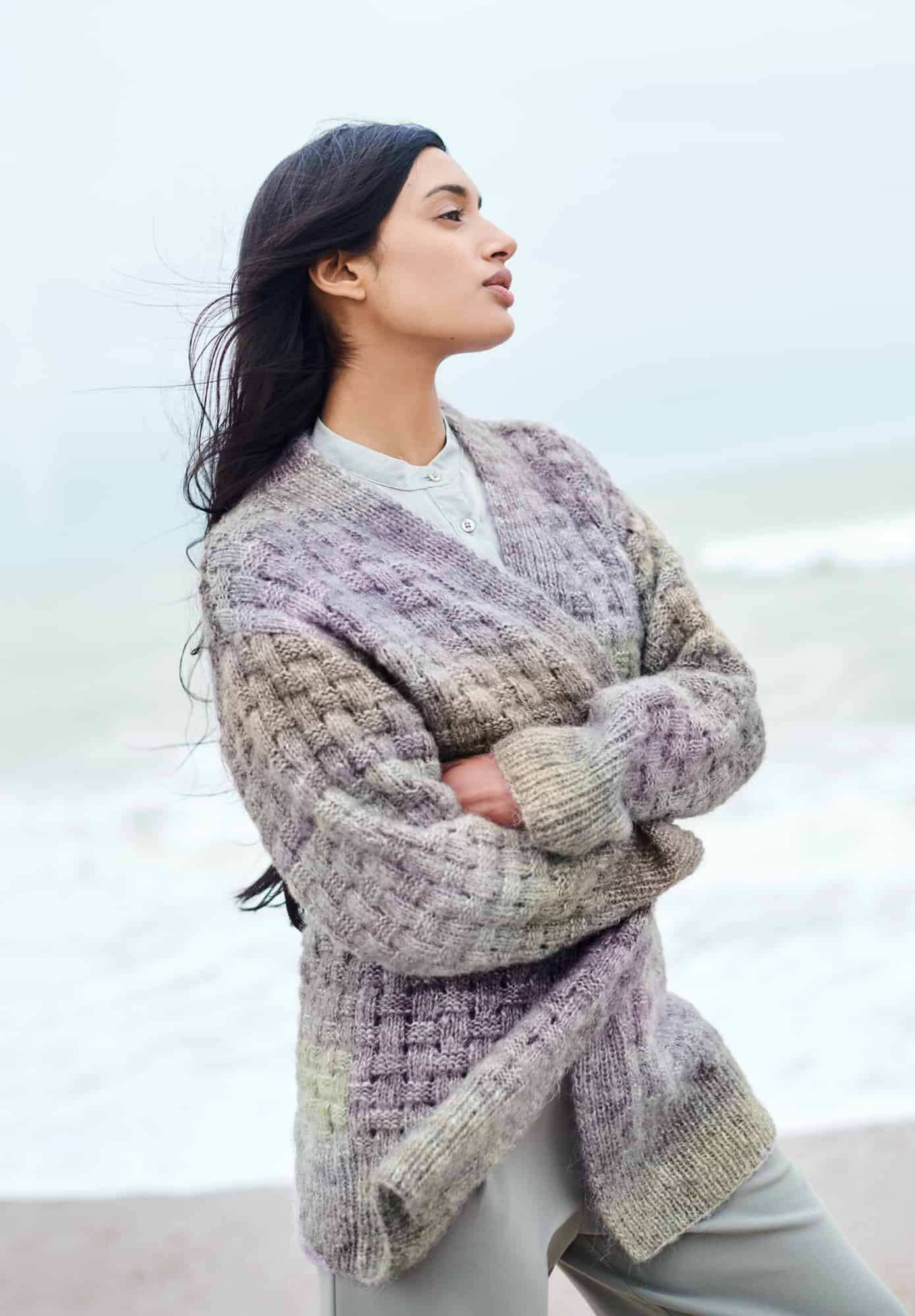 Frau trägt gestrickte Jacke mit Flechtmuster in Pastellfarben: Modell 21 aus Lovewool No. 21