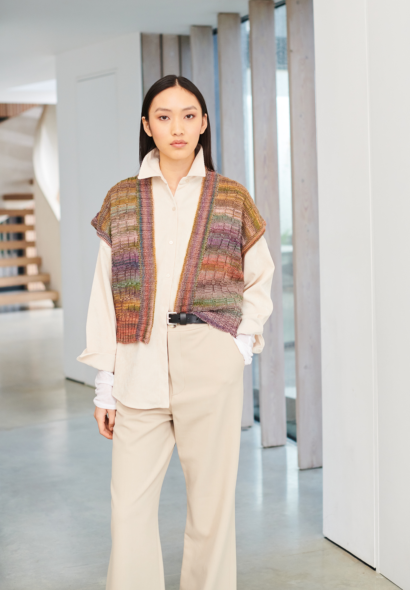 Frau trägt gestrickte Weste mit Farbverlauf in warmen Tönen: Modell 11 aus Lovewool No. 19