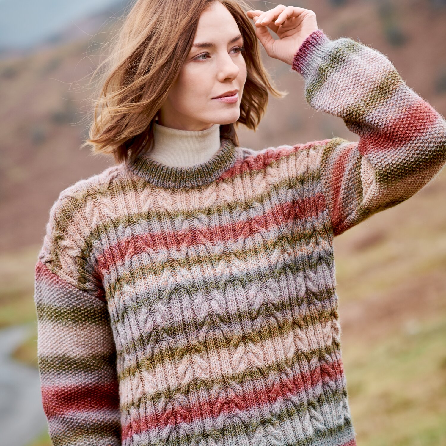 Strickset Pullover Modell 39 aus Lovewool No. 23, locker sitzender Damenpullover mit breiten, mehrfarbigen Streifen in Natur- und Pastelltönen, getragen im Freien