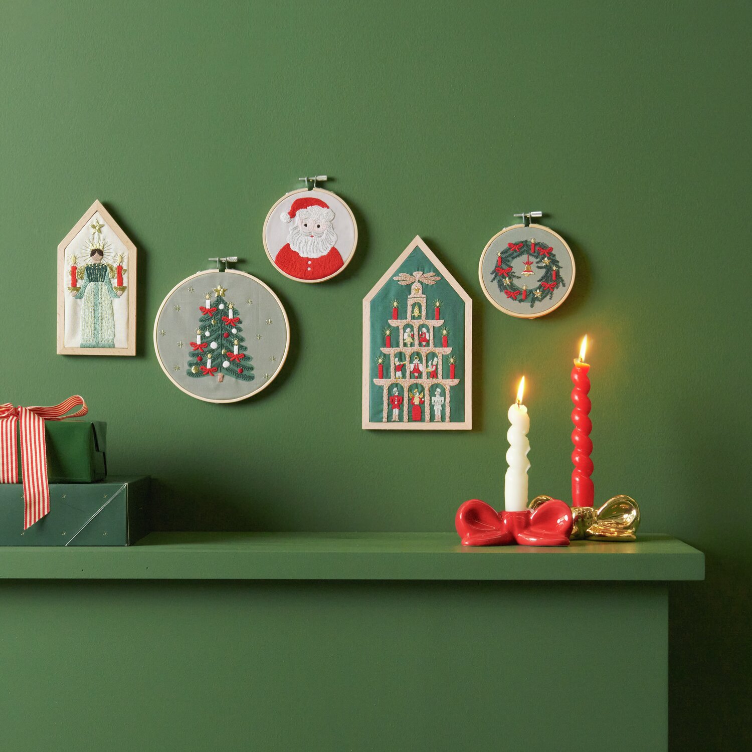 Stickpackung Weihnachtskranz vorgezeichnet Ø10cm von Rico Design Stickpackung Weihnachtskranz vorgezeichnet: Fünf weihnachtliche Stickbilder an grüner Wand, darunter Kerzen und Geschenke.