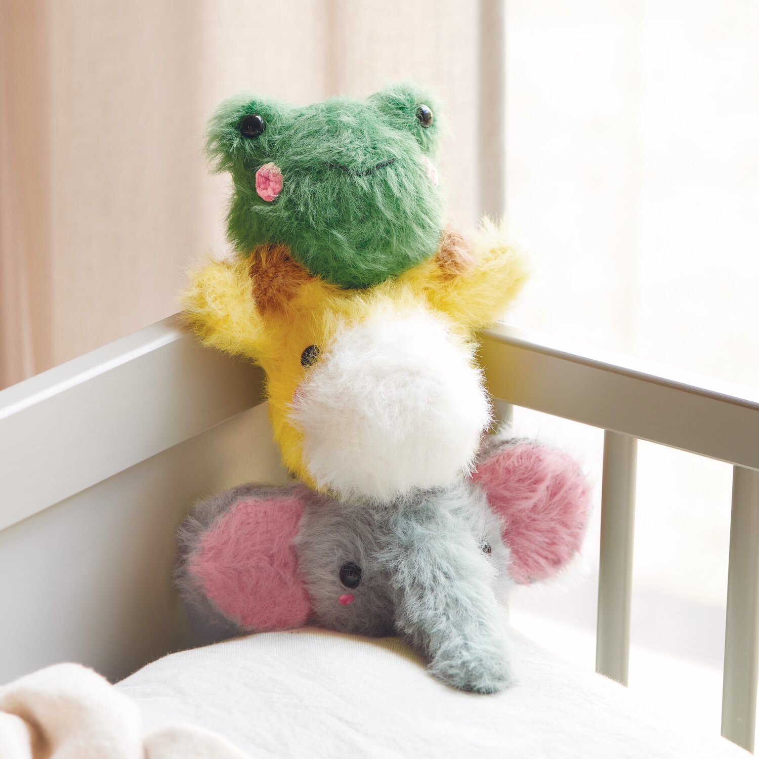 Ricorumi Furry Animals: Flauschige Stofftiere in Grün, Gelb und Grau mit Sicherheitsaugen auf einem Kinderbett.