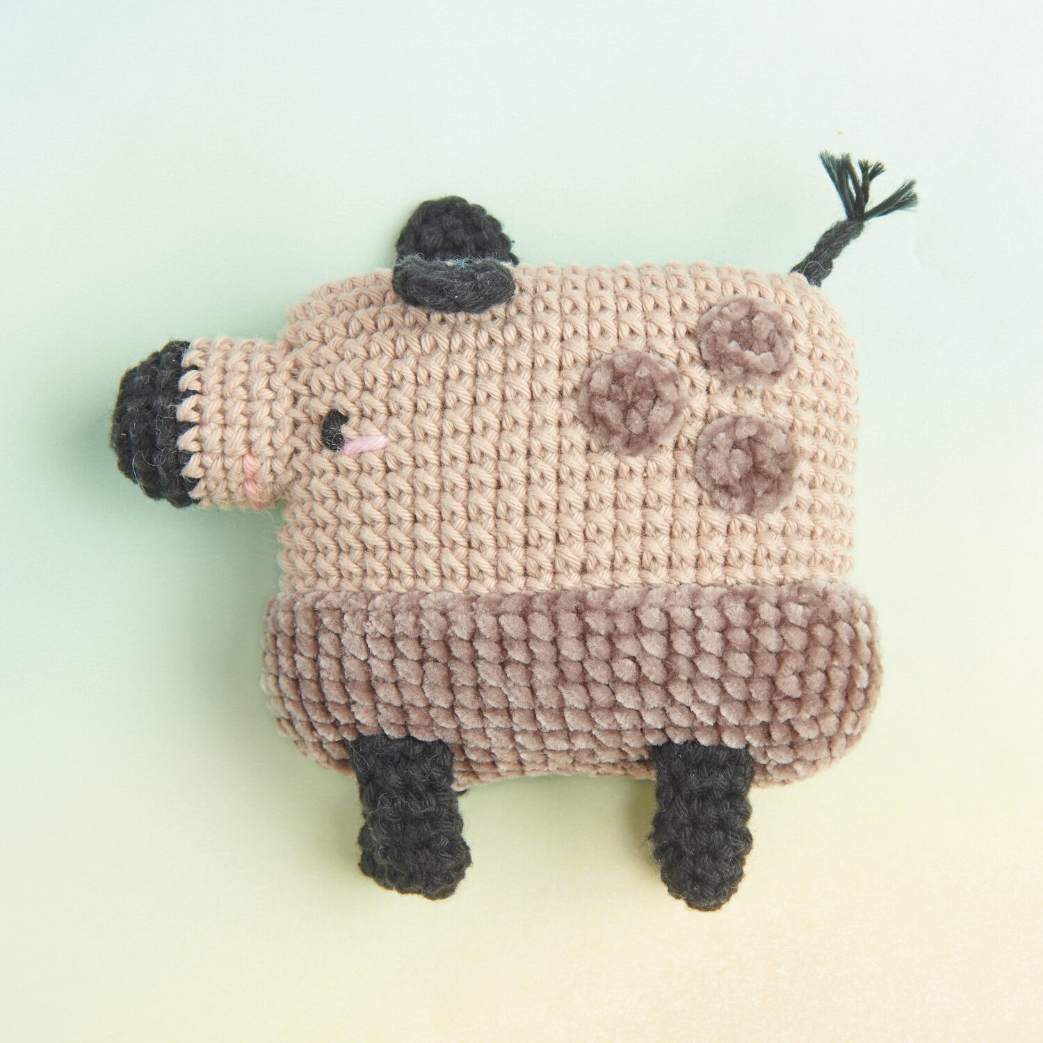 Ricorumi Rainbow Weirdos, gehäkeltes Tier in Beige und Schokolade, mit schwarzen Details.