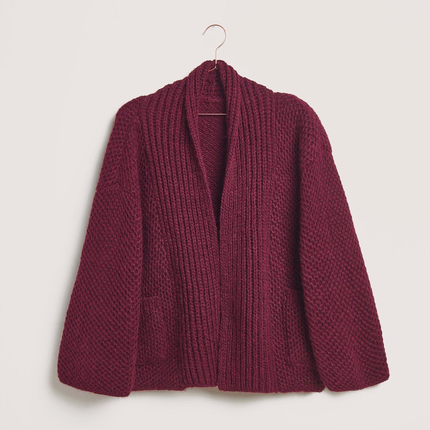 Stickset Jacke Modell 29 aus Made by Me No. 21: Bordeauxfarbene Strickjacke aus Alpaka-Merinowolle, präsentiert auf einem Kleiderbügel.