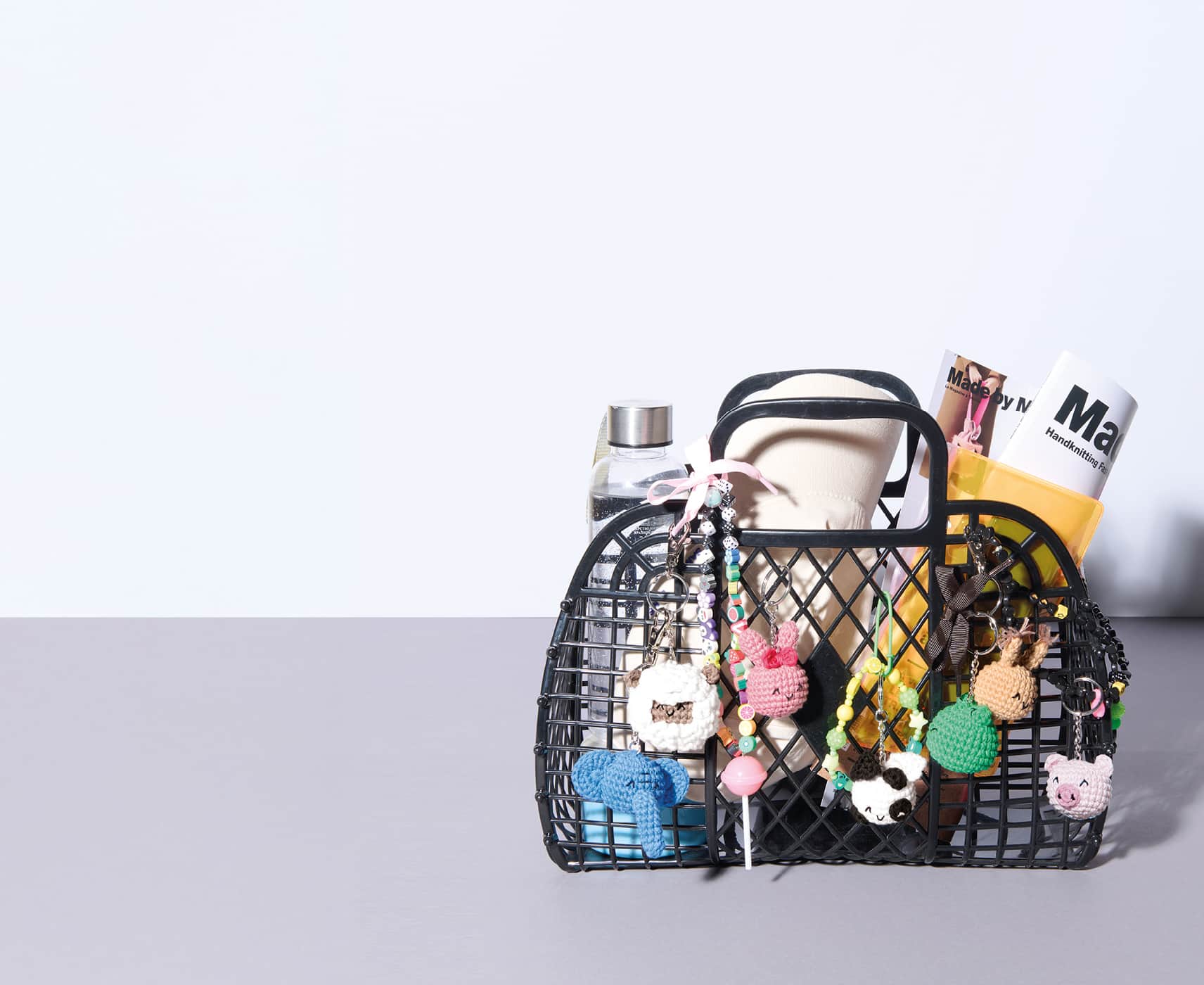 Ein gefüllter Korb ist mit vielen gehäkelten Tier-Anhängern geschmückt.