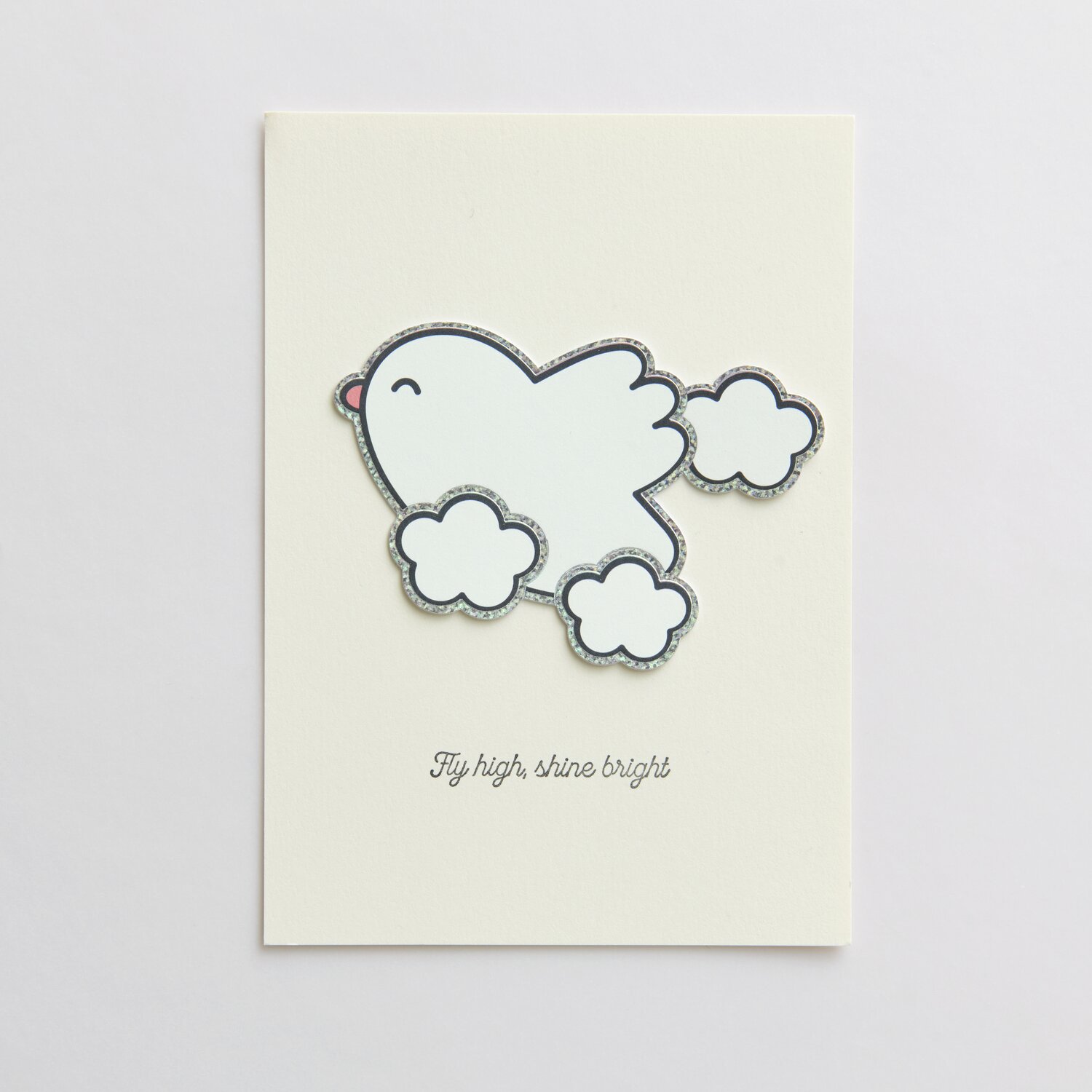 Paper Poetry Clip-Ons Chingu Wolken/Herzen Weiß: Weiße Karte mit fliegendem Vogel und Wolkenmotiv. Text: "Fly high, shine bright".