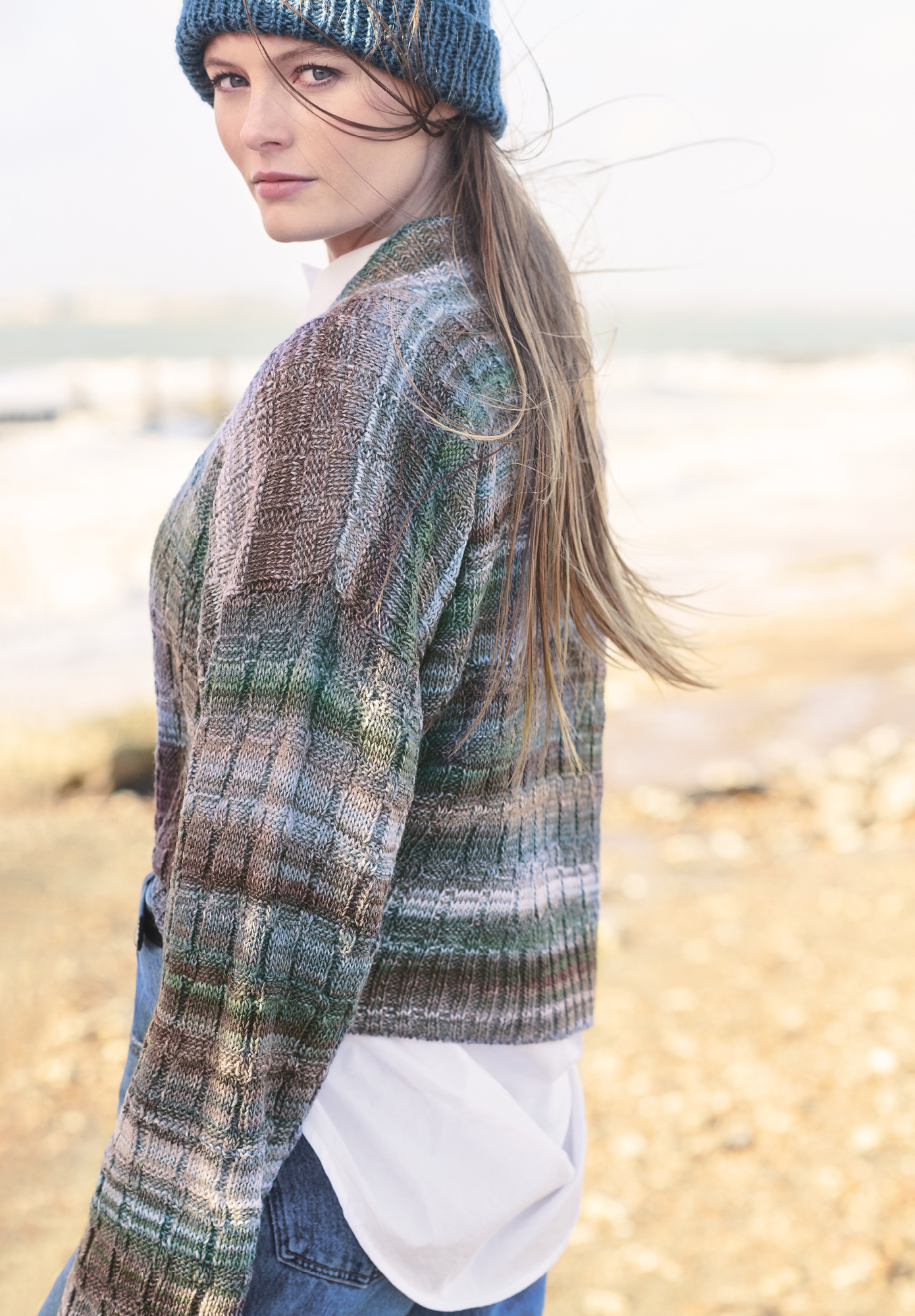 Frau trägt gestrickte Jacke mit Farbverlauf in Braun und Blau Tönen: Modell 40 aus Lovewool No. 19