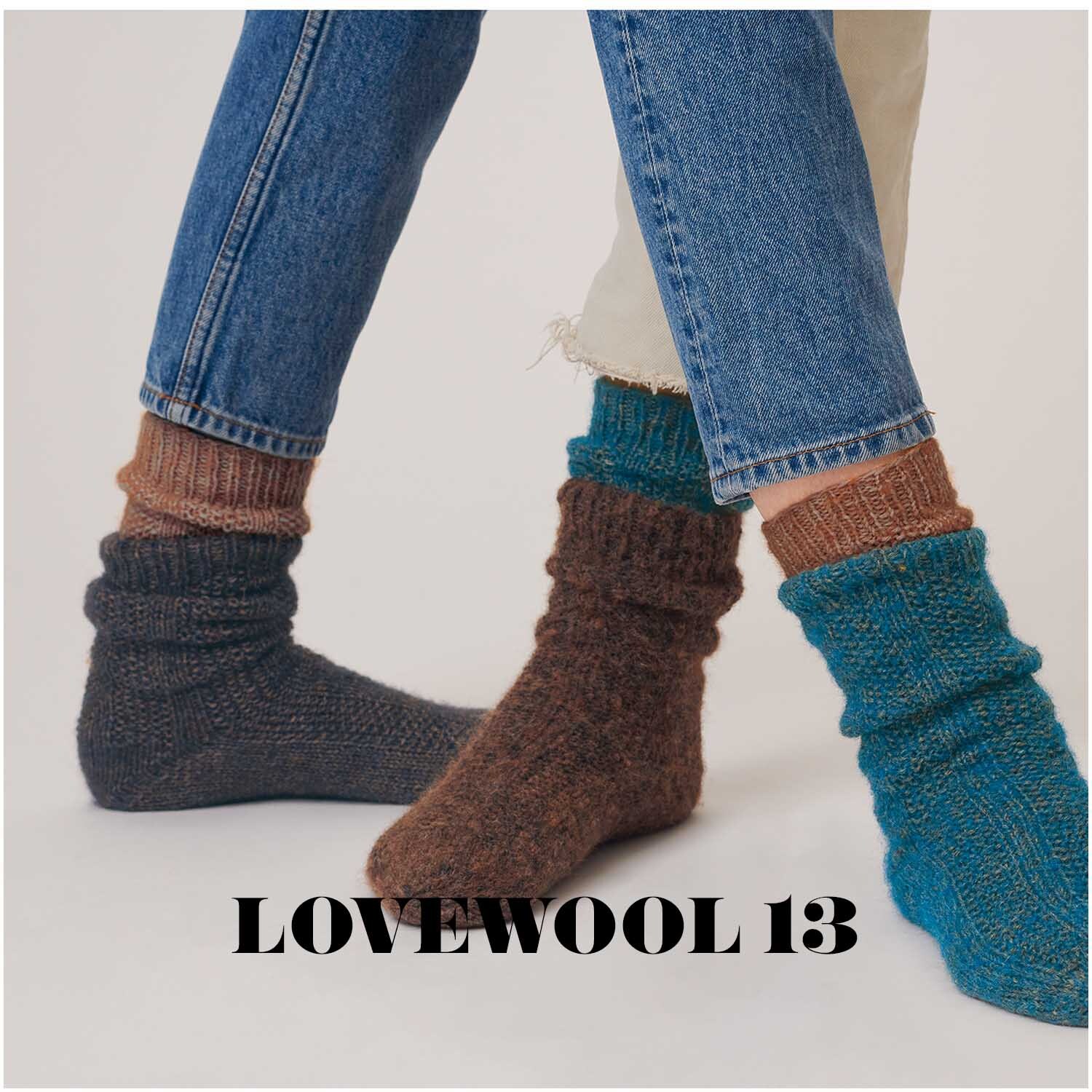 Superba Alpaca Luxury Socks: Zwei Personen tragen gestrickte Socken in verschiedenen Farben, kombiniert mit Jeans.