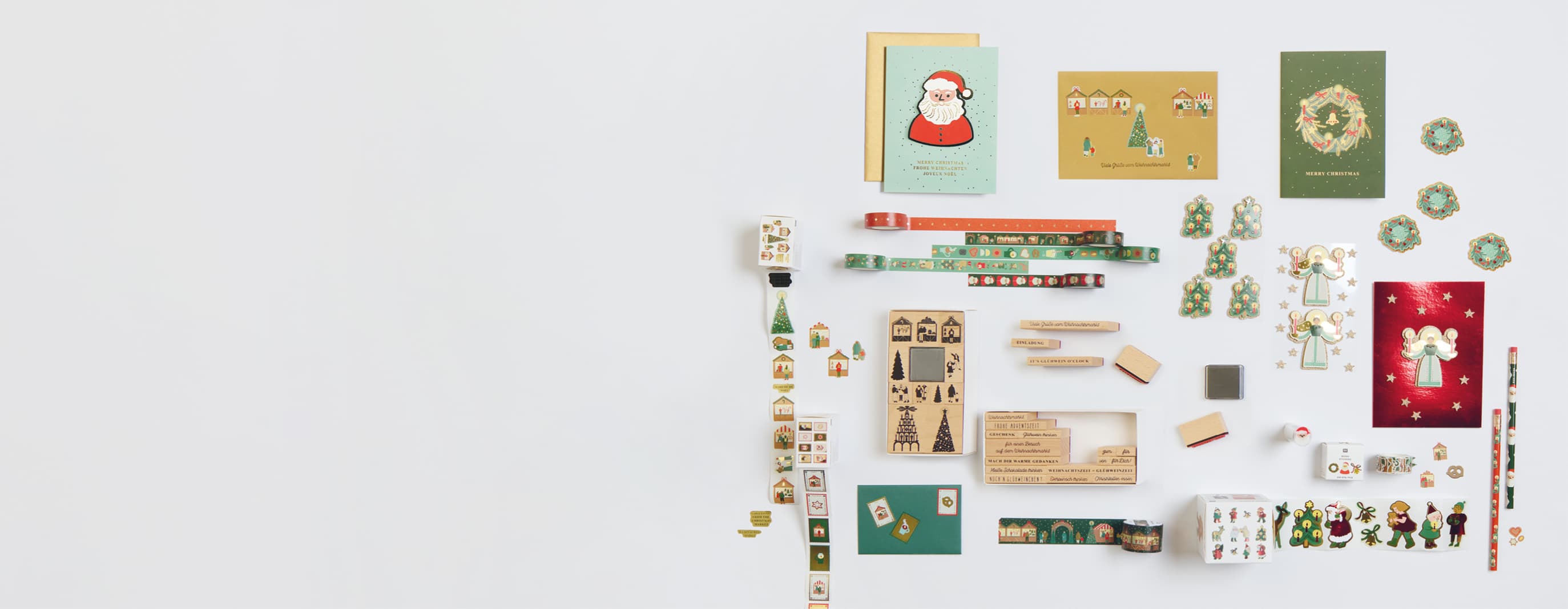 Sticker, Stempel, Karten und Glanzbilder mit Motiven vom Weihnachtsmarkt sind auf grauem Hintergrund angeordnet.