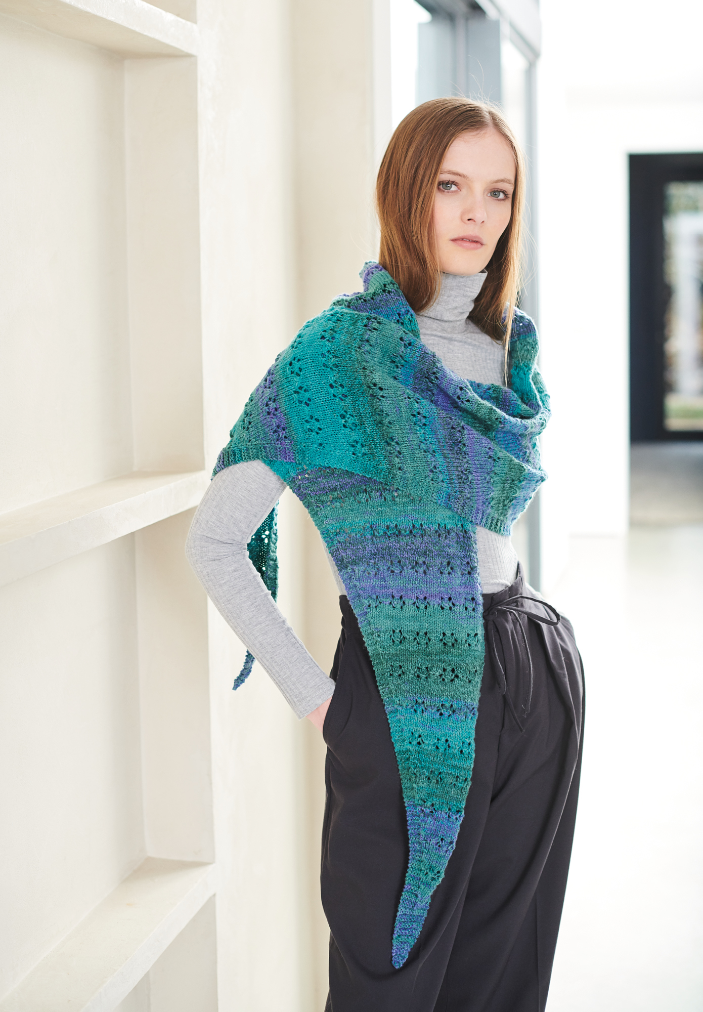 Frau trägt gestricktes Dreieckstuch mit Farbverlauf in Grün-Blau: Modell 33 aus Lovewool No. 19