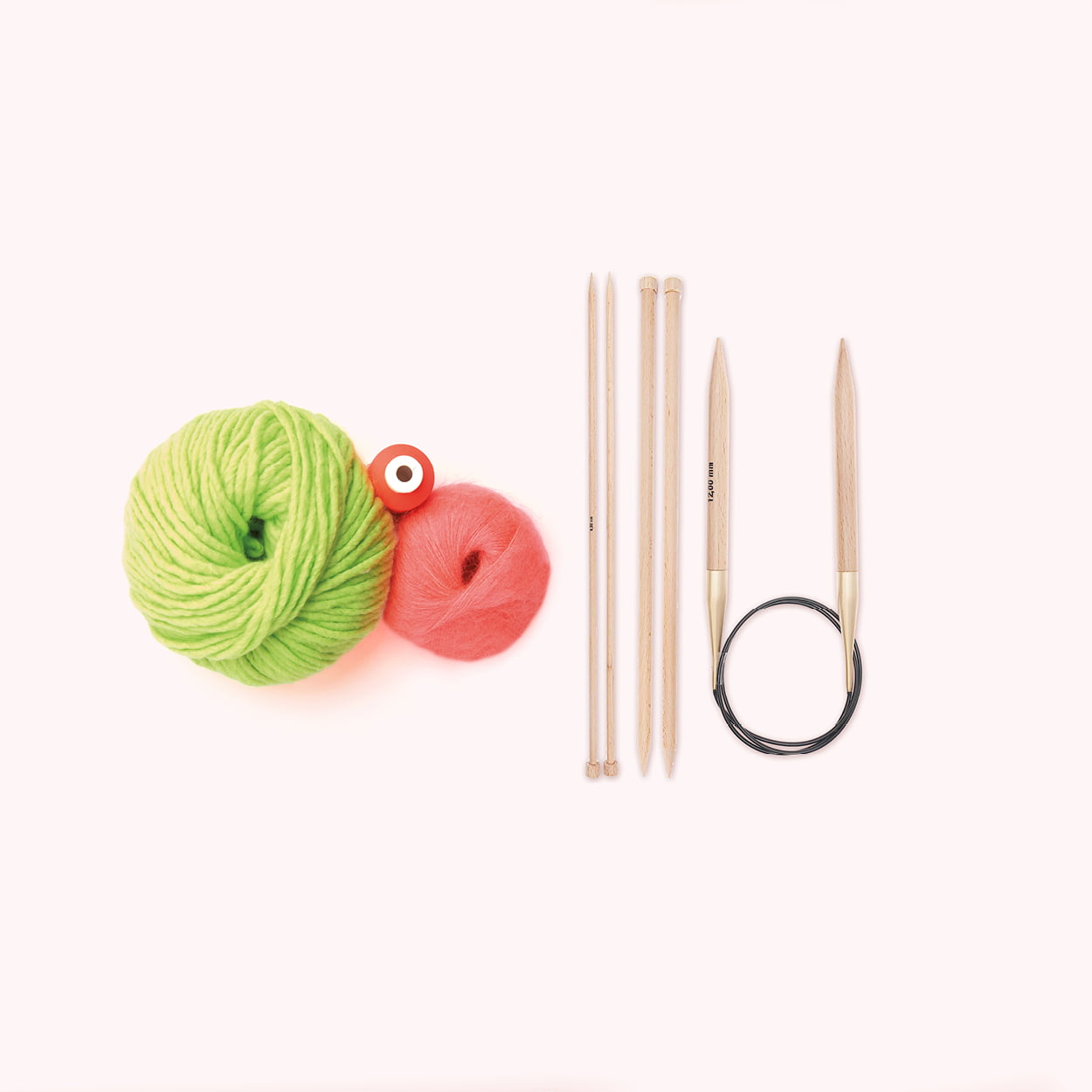 Stricknadeln und Wollknäuel liegen auf einem beigem Hintergrund