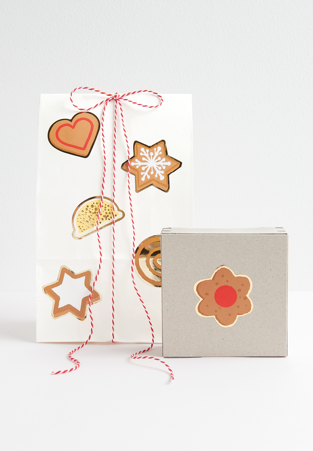 Sticker im Plätzchen-Design schmücken dekorativ eine Papiertüte und Geschenkbox 
