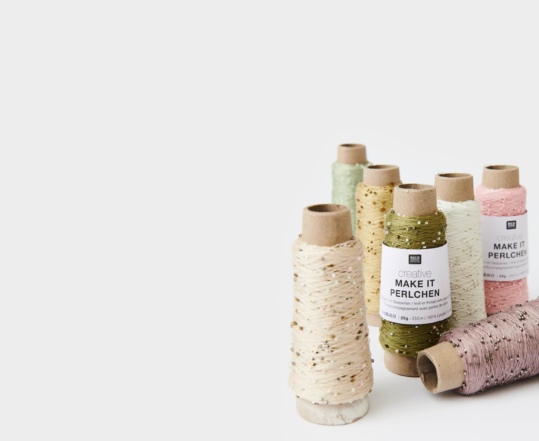 Verschiedene Garnrollen von Creative Make it Perlchen sind beisammen aufgestellt.