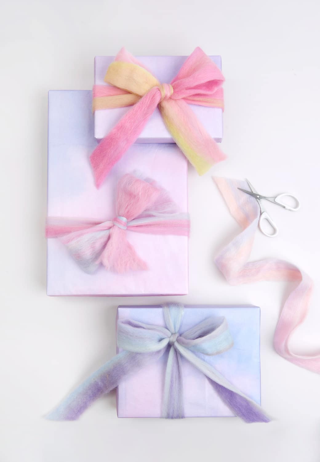 Verpackte Geschenke sind mit Filzband geschmückt.