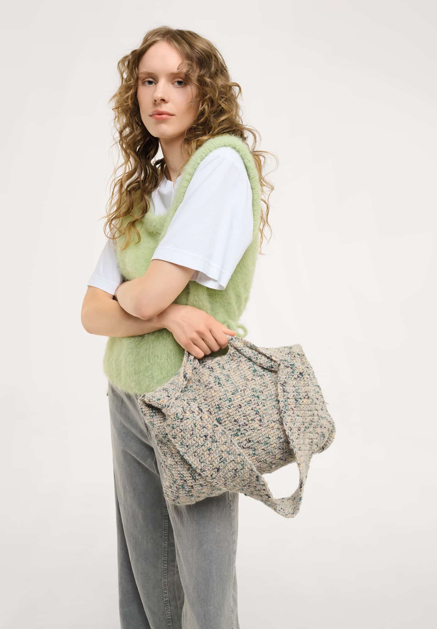 Frau trägt gehäkelte Tasche in Grau meliert: Modell 11 aus Made by Me No. 22