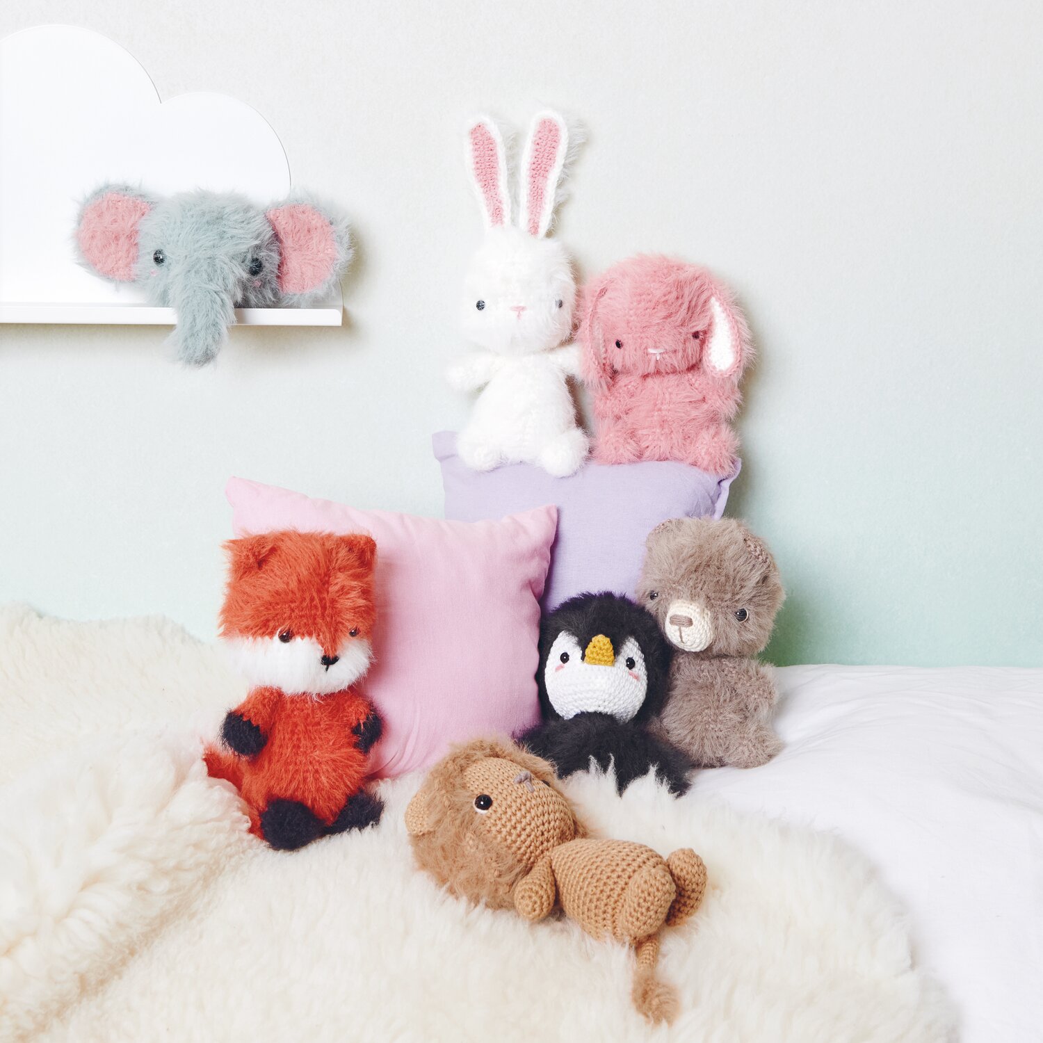Ricorumi Furry Animals: Kuschelige Stofftiere in verschiedenen Farben auf einem weißen Bett arrangiert.