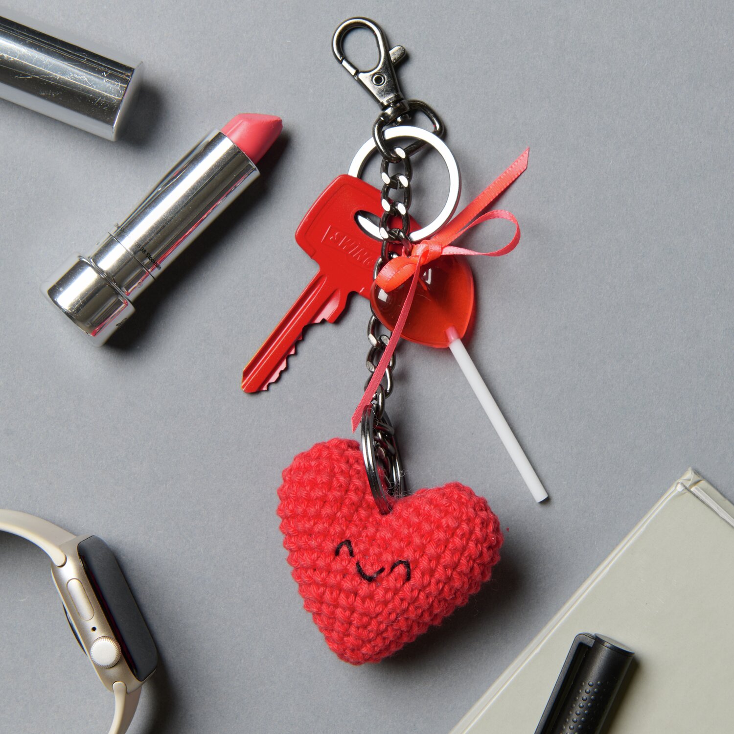 Karabiner mit Kette und Schlüsselring 13cm von Rico Design Karabiner mit Kette und Schlüsselring 13cm, silber, mit rotem Herzanhänger und Schlüssel auf grauem Hintergrund.