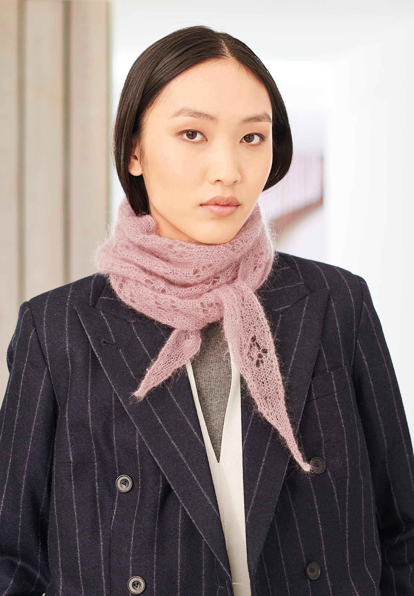 Frau trägt gestricktes Dreieckstuch in Rosa: Modell 13 aus Lovewool No. 19