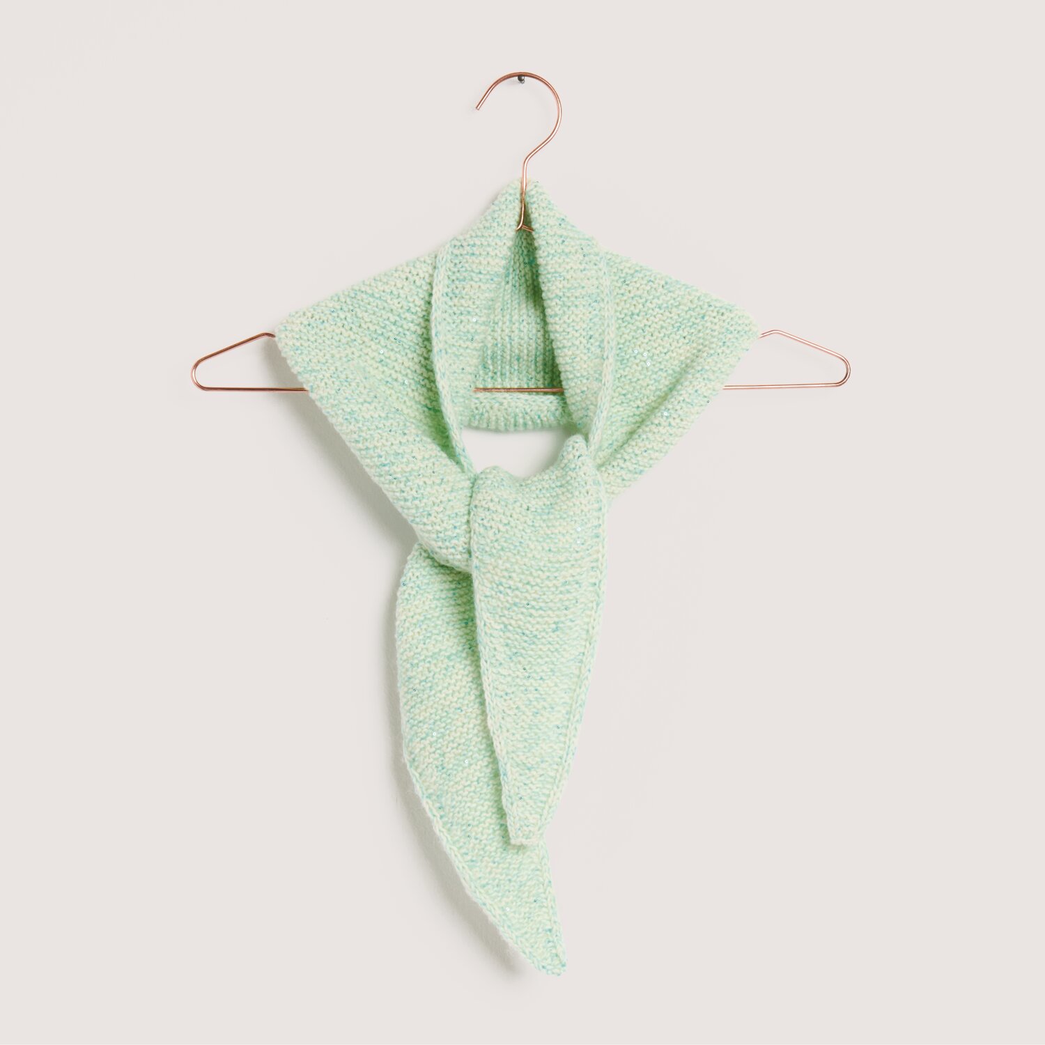 Made by Me No. 22 Frühjahr-Sommer: Ein gestrickter Schal in sanftem Türkis hängt auf einem Kupferbügel.