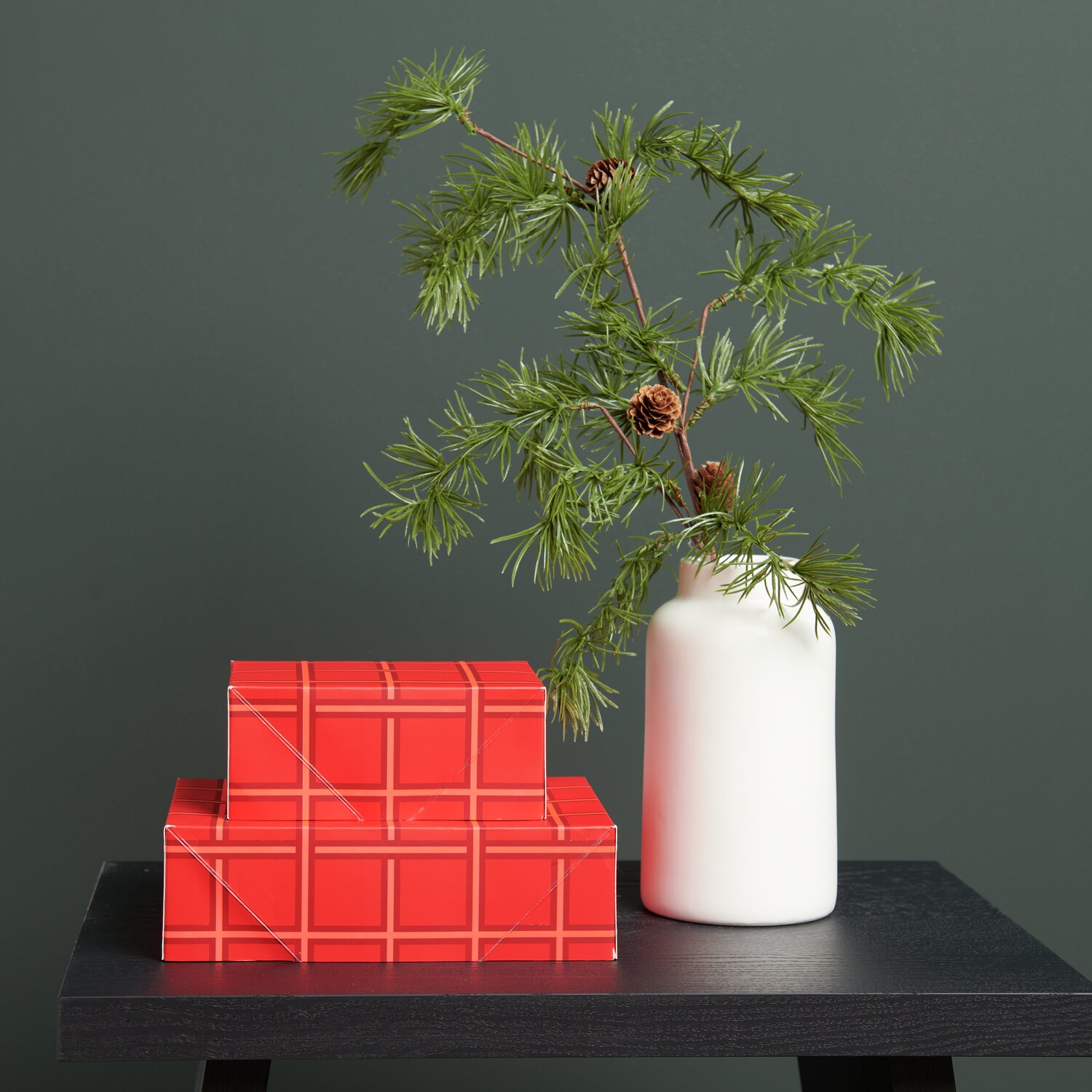 Paper Poetry Papierschachtel Set Raster, rot, neben weißer Vase mit Lärchenzweig und Zapfen auf schwarzem Tisch.