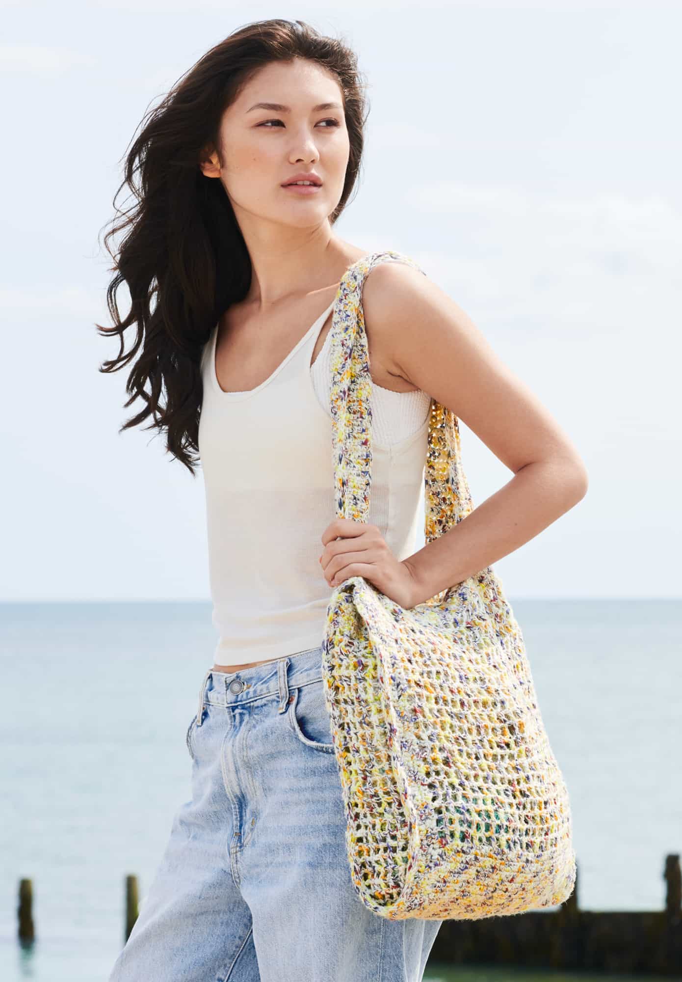 Frau trägt gehäkelte Tasche in Creme und Gelb meliert: Modell 28 aus Lovewool No. 22