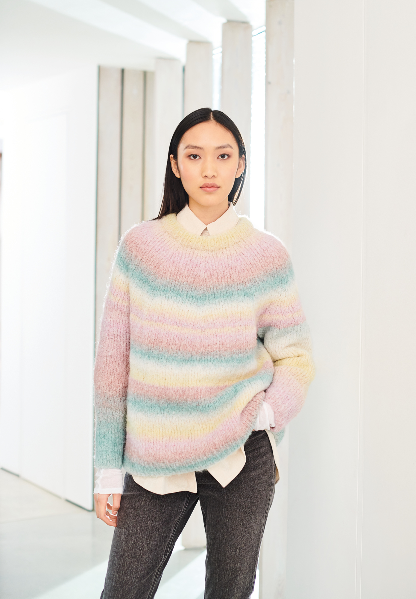 Frau trägt gestrickten Pullover in Pastellfarben: Modell 16 aus Lovewool No. 19