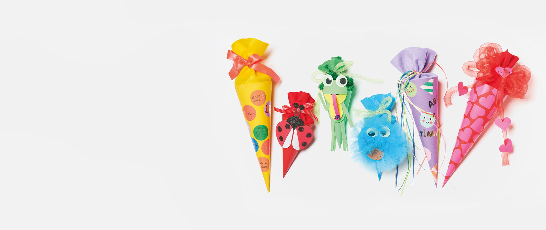 Sechs gebastelte Schultüten in verschiedenen Farben und Designs, darunter Marienkäfer-, Frosch- und Krümelmonsterfigur