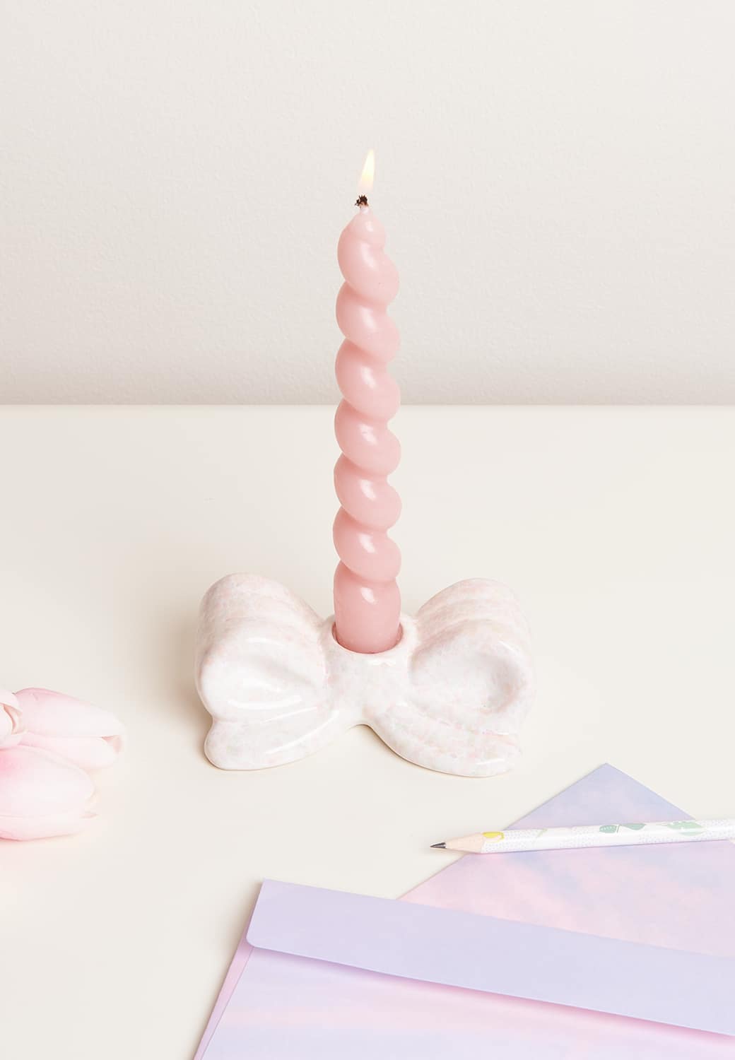 Eine Spiralkerze steht in einem Kerzenständer in Schleifenform.