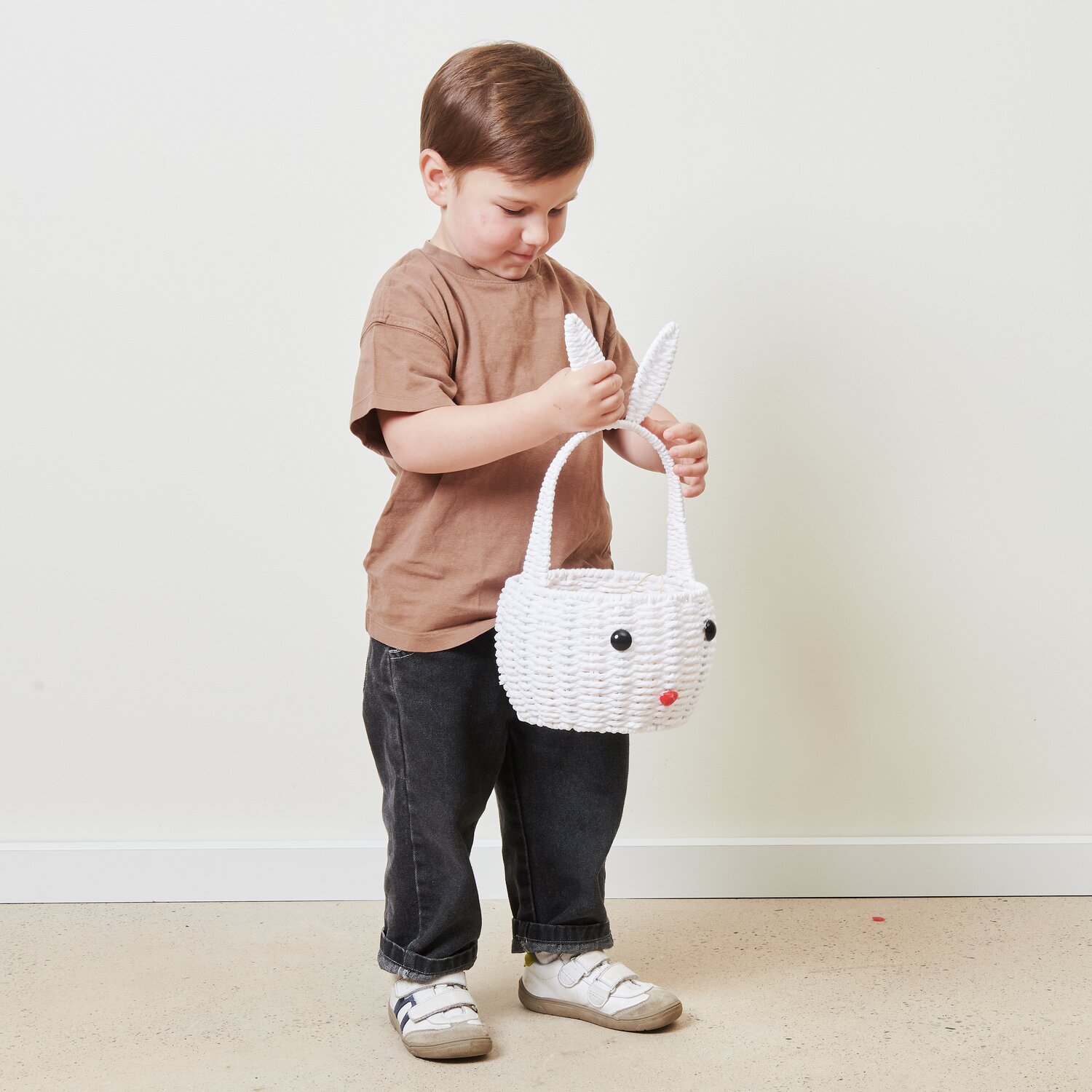 Osterkorb Hase: Kind hält weißen Korb in Hasenform von Rico Design, ideal für Ostern.