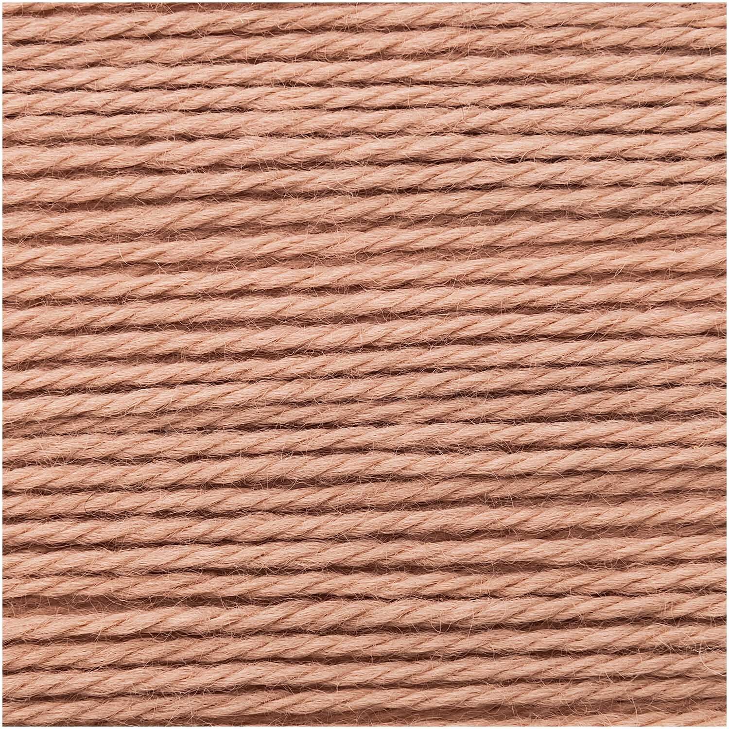Essentials Merino Plus dk von Rico Design in Puder, 50g Knäuel mit 125m Länge, zeigt weiche, gleichmäßige Wollfäden.