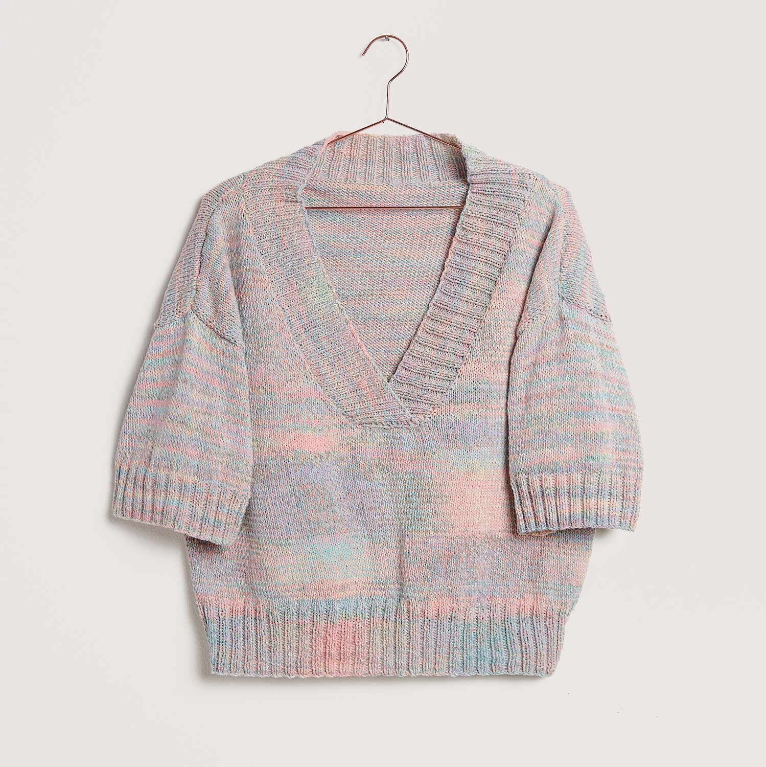 Die Neue Masche No. 12 Frühjahr-Sommer Pullover mit V-Ausschnitt in Pastelltönen auf Bügel.