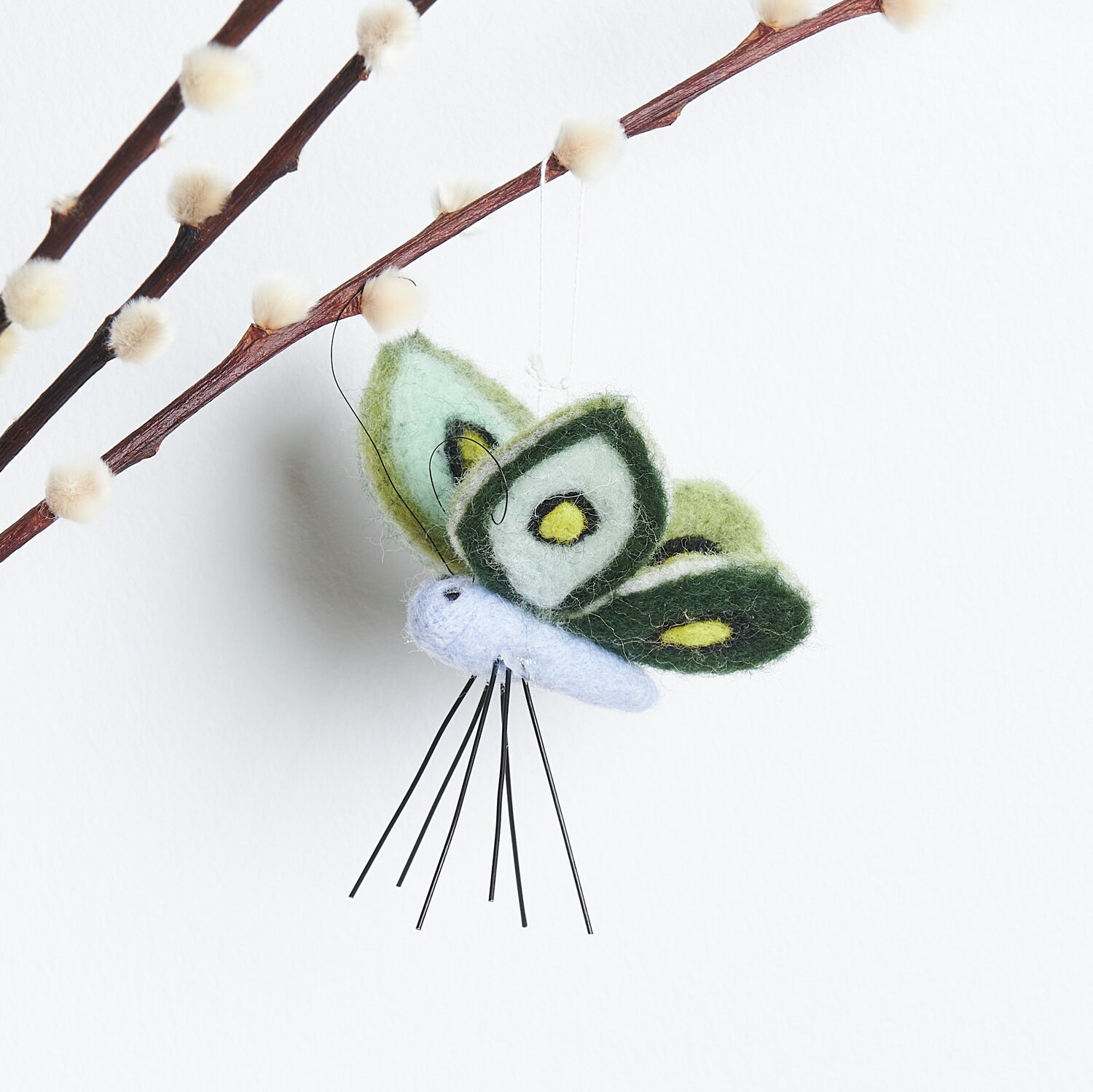 Aufhänger Filz-Schmetterling: Dekorativer Schmetterling aus Filz in Hellblau, 10x10,5x7cm, an Zweig hängend.