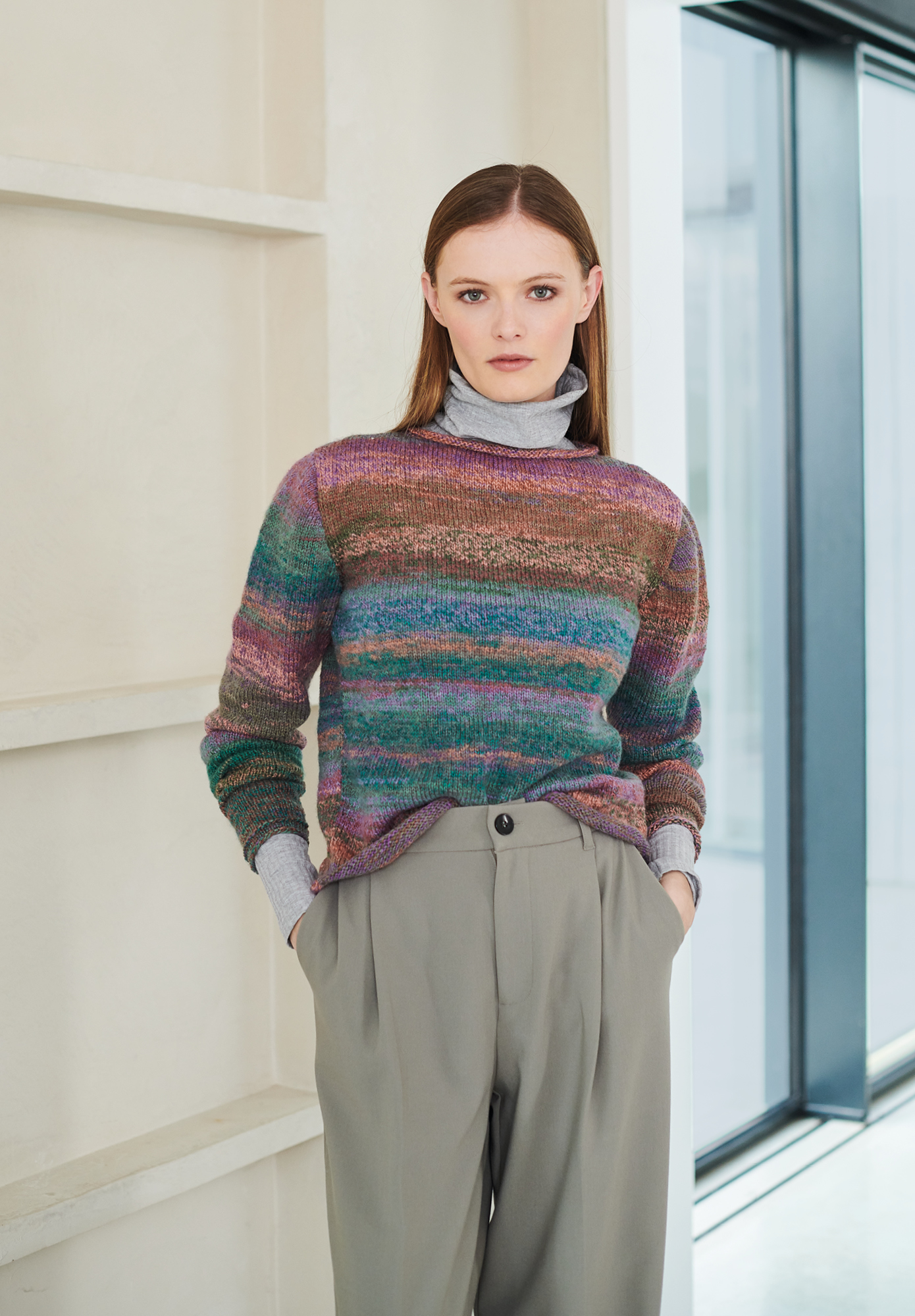 Frau trägt gestrickten Pullover mit Farbverlauf in Blau, Lila und Braun: Modell 36 aus Lovewool No. 19