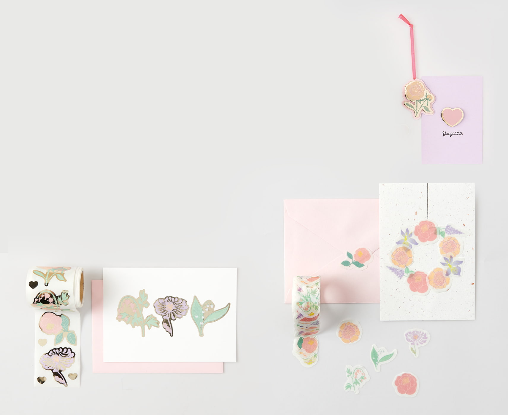 Sticker auf der Rolle und Washisticker mit Blumenmotiven kleben auf Karten und Umschlägen und liegen dekorativ um die Papeterie herum. 