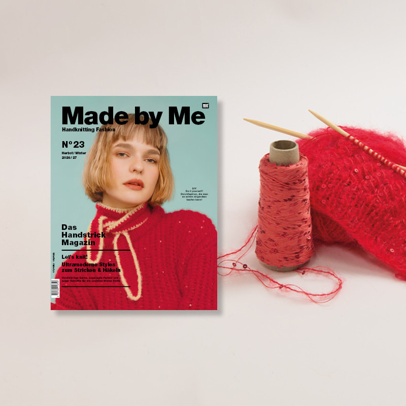 Strickmagazin Made by Me Nr. 23 neben Wollknäuel und Strickstück auf Stricknadeln.