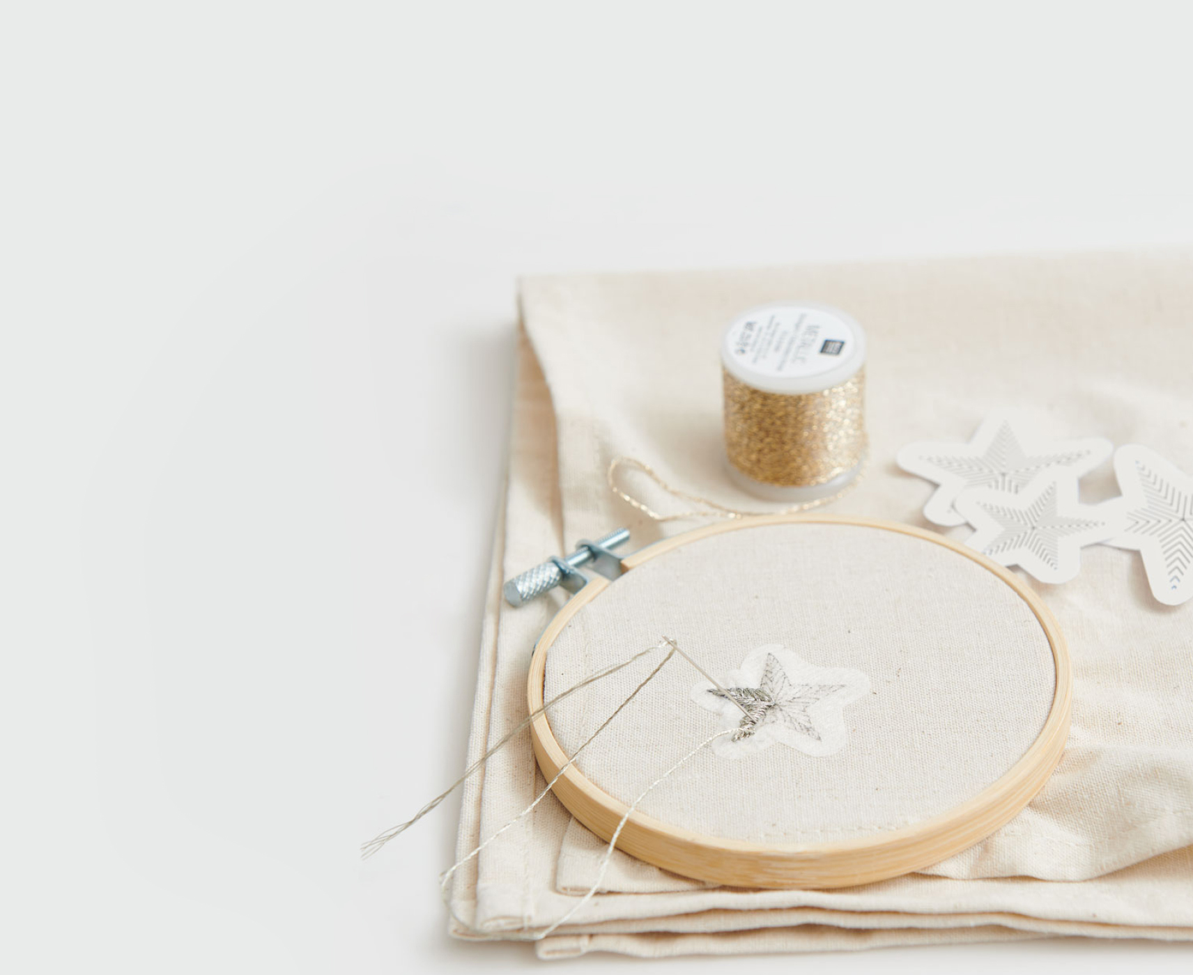 Ein Stick & Stitch-Aufkleber in Sternform klebt auf einem Stoff und wird bestickt.