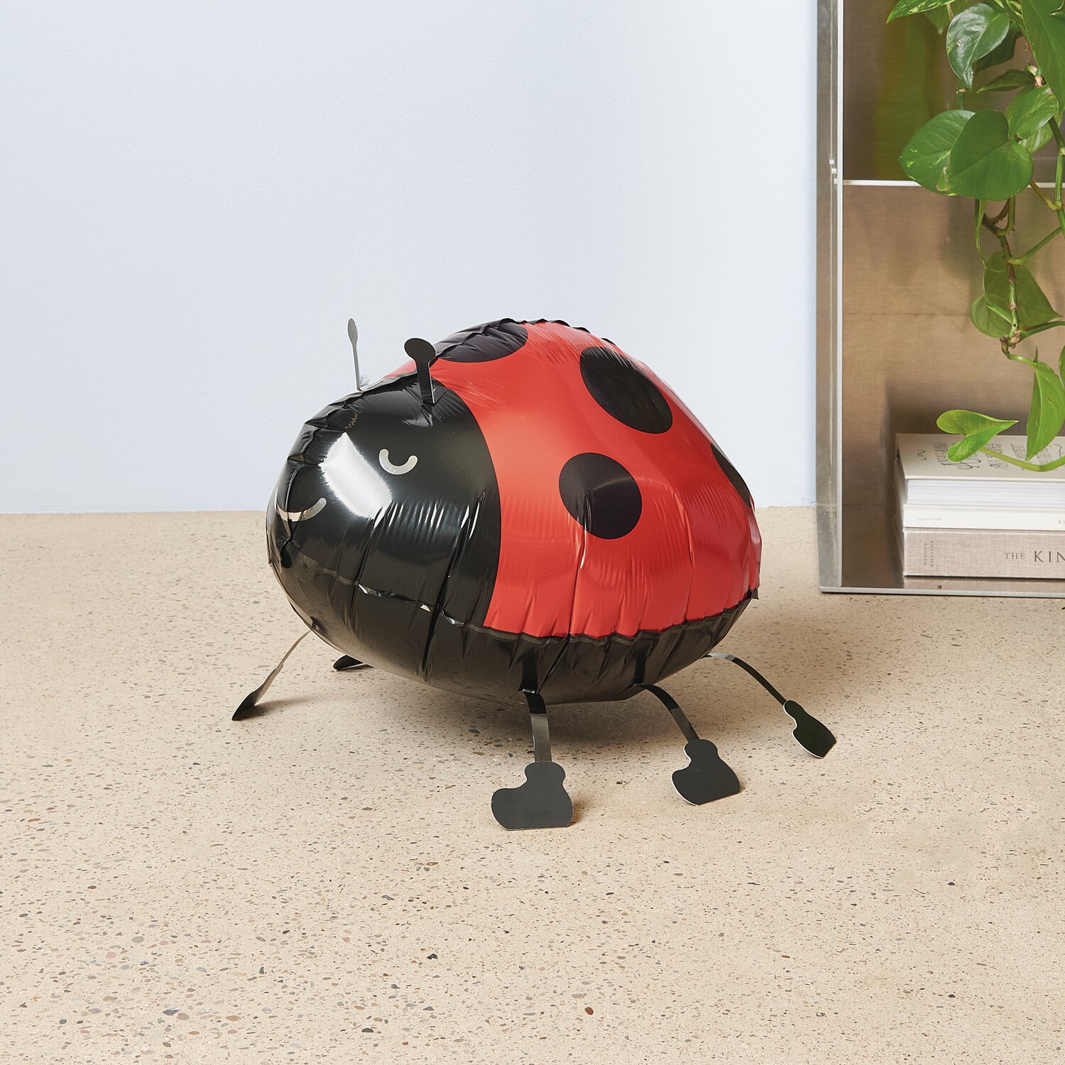 Folienballon Airwalker Marienkäfer in Rot und Schwarz, 36x24x29cm, auf hellem Boden.