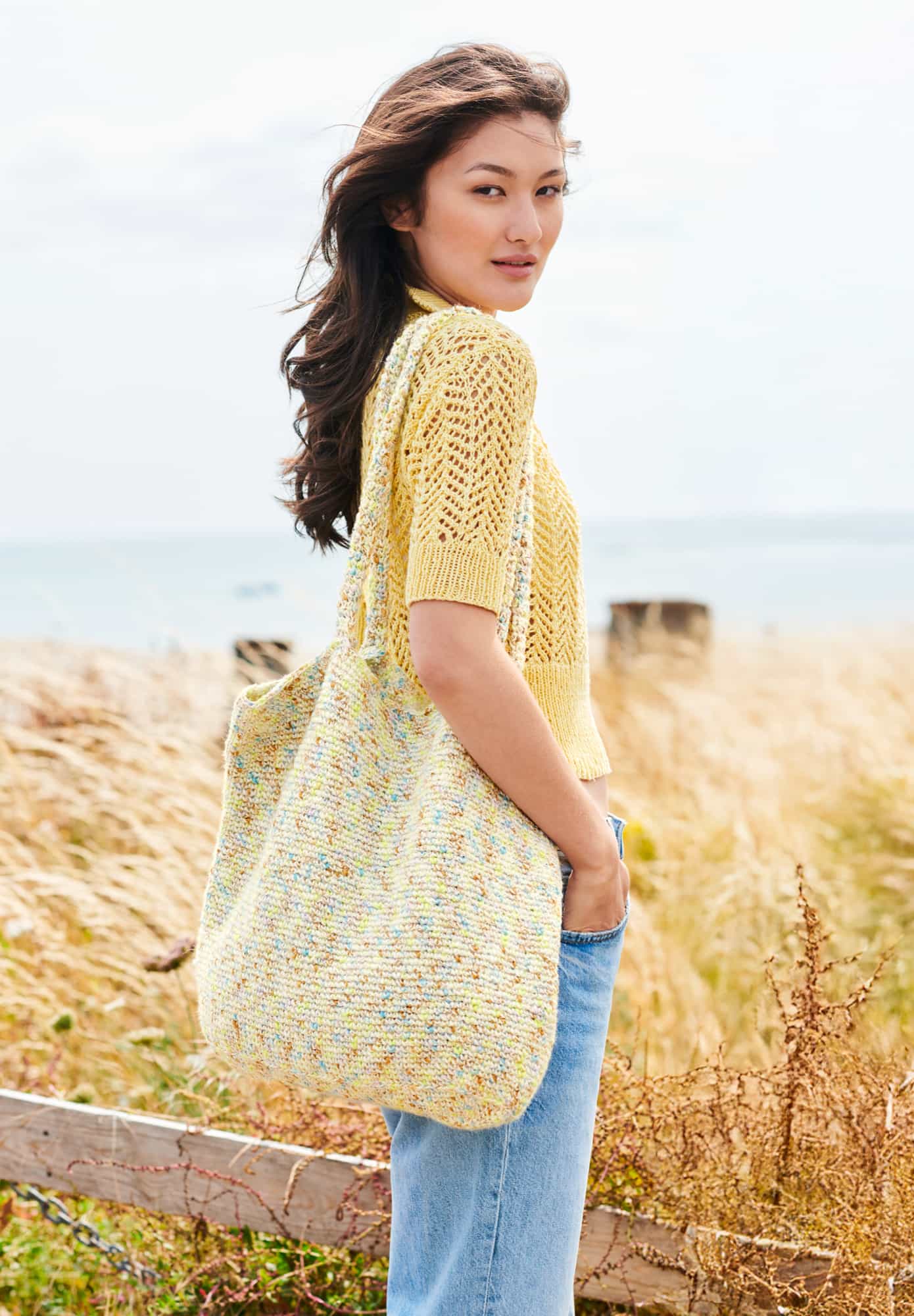 Frau trägt gehäkelte Tasche in Creme und Gelb meliert: Modell 05 aus Lovewool No. 22