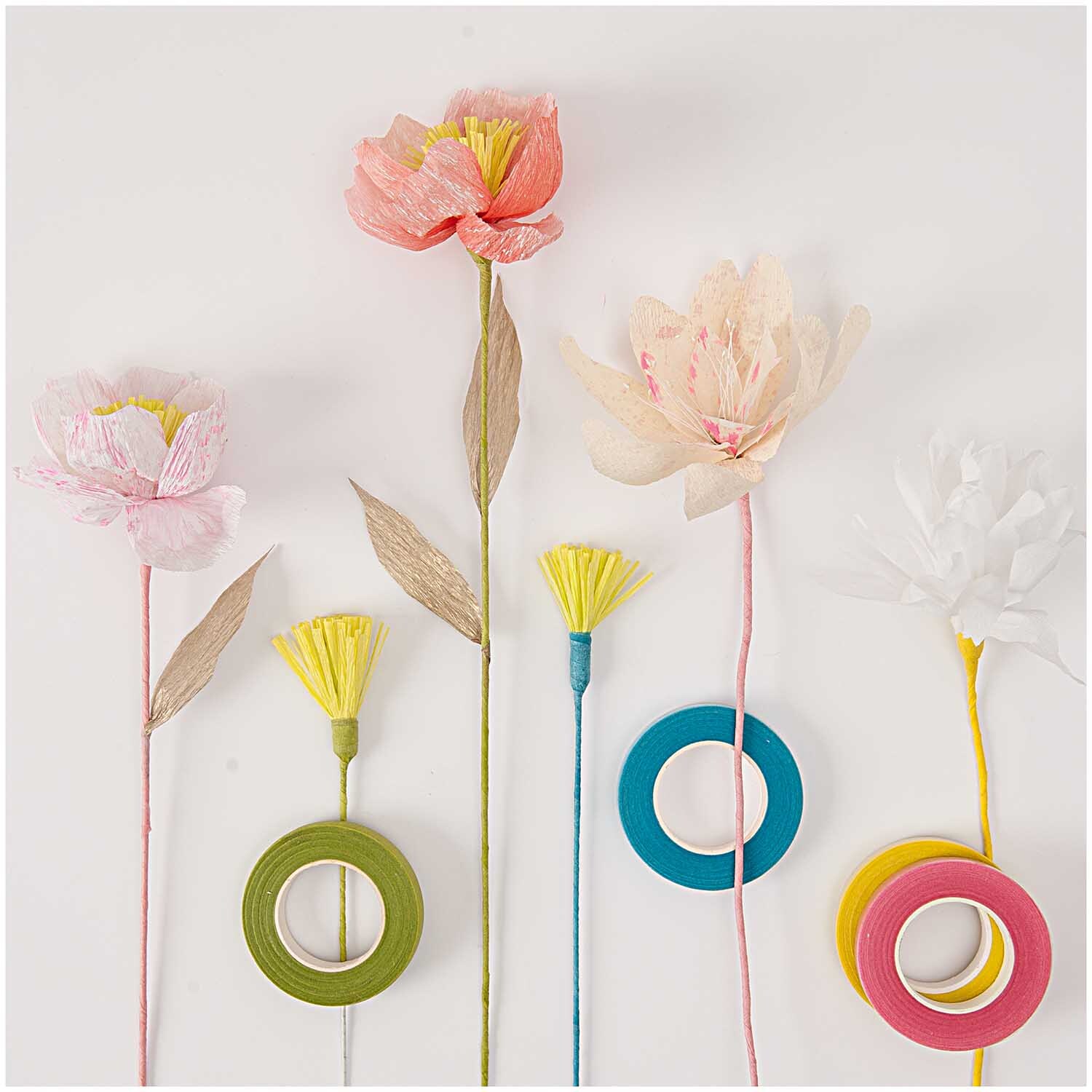 Floristenkrepp von Rico Design in Graubeige, 25x250cm. Bild zeigt bunte Kreppblumen und Bastelmaterialien.