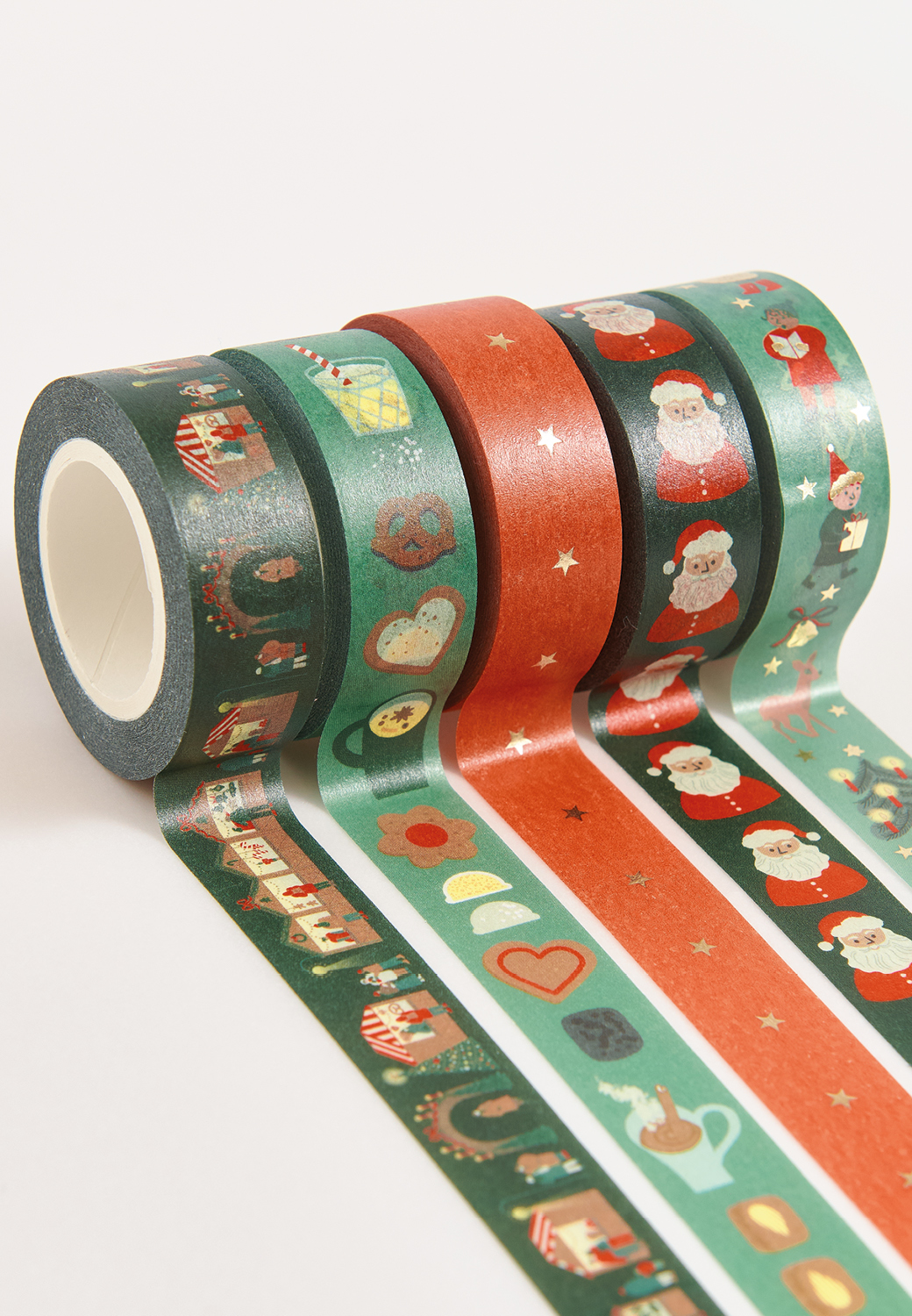 Washi Tapes mit weihnachtlichen Designs liegen abgerollt nebeneinander