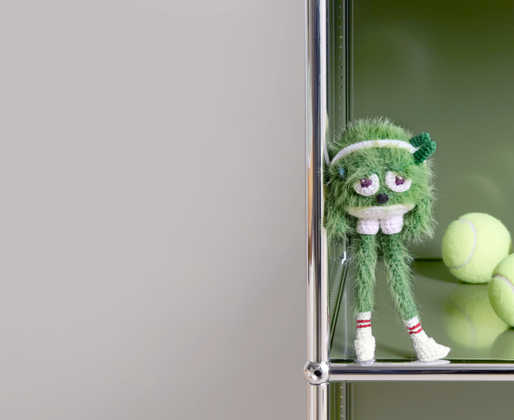 Ein gehäkeltes Monster steht in einem Regal.