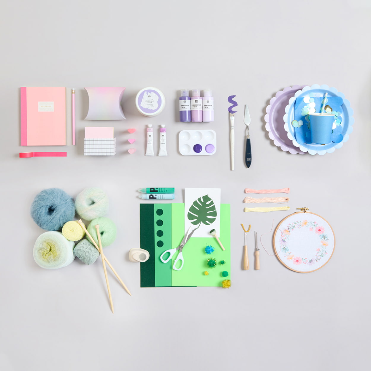 Papeterie Artikel, Künstler- und Bastelmaterial, sowie Zubehör für Handarbeiten liegen auf grauem Hintergrund.