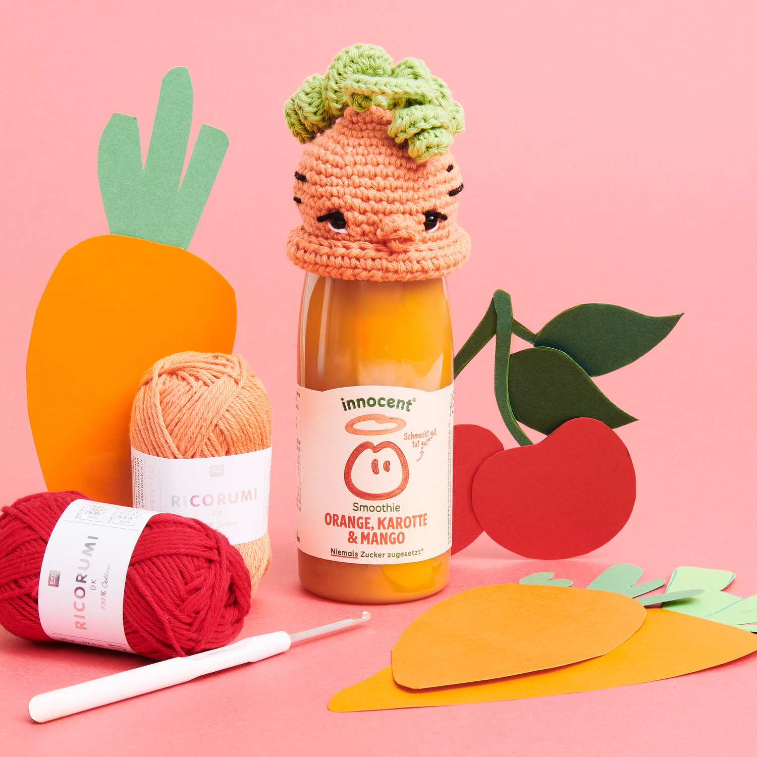 Häkelanleitung Ricorumi Mützchen Möhre: Flasche mit gehäkeltem Mützchen, Wolle und Papierdeko.